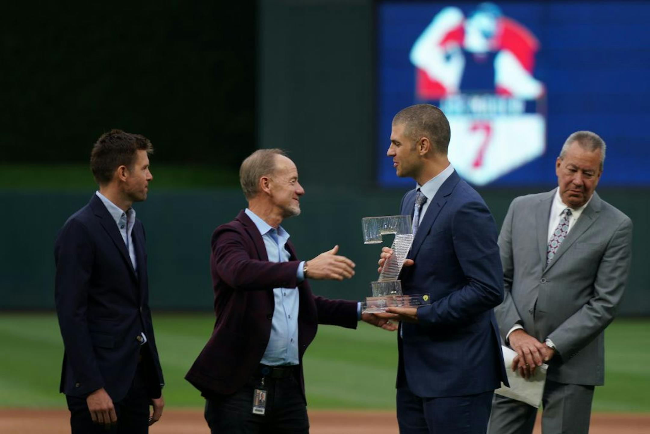 Former Minnesota Twins star Joe Mauer got a gift and hug from team owner Jim Pohlad during a pregame ceremony to retire his number 7 Saturday.