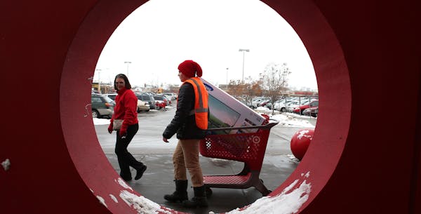 Denise Dian, of Roseville, lead Wyatt Buchanan, Target employee, to her car so that he could help her pack it in at the Target in Roseville Saturday, 