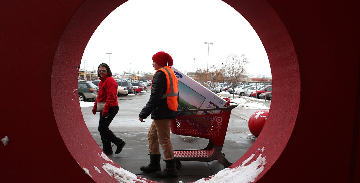 Denise Dian, of Roseville, lead Wyatt Buchanan, Target employee, to her car so that he could help her pack it in at the Target in Roseville Saturday, December 21, 2013. Dian decided to do more shopping with the 10% discount. "I always buy on sale. I would have bought that item maybe next week maybe four weeks from now, two months from now instead i bought it today, " she said. "The freezer was half full. I wasn't going to fill it up today but on sale plus, 10 plus 5% we're going to fill it up to