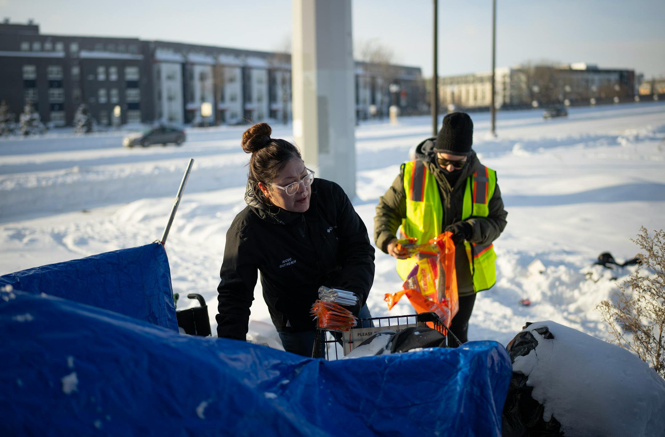 Outreach worker Dava Beaulieu talked to a man in one of he tents in an encampment along Hiawatha Ave. as she and Leah Skjefte checked on their well being and offered hand warmers and snacks Thursday afternoon. Homeless outreach workers for the American Indian Community Development Corp. (AICDC), checked several homeless encampments to offer hand warmers and snacks or a ride to a shelter on a dangerously cold afternoon in Minneapolis Thursday, December 22, 2022.