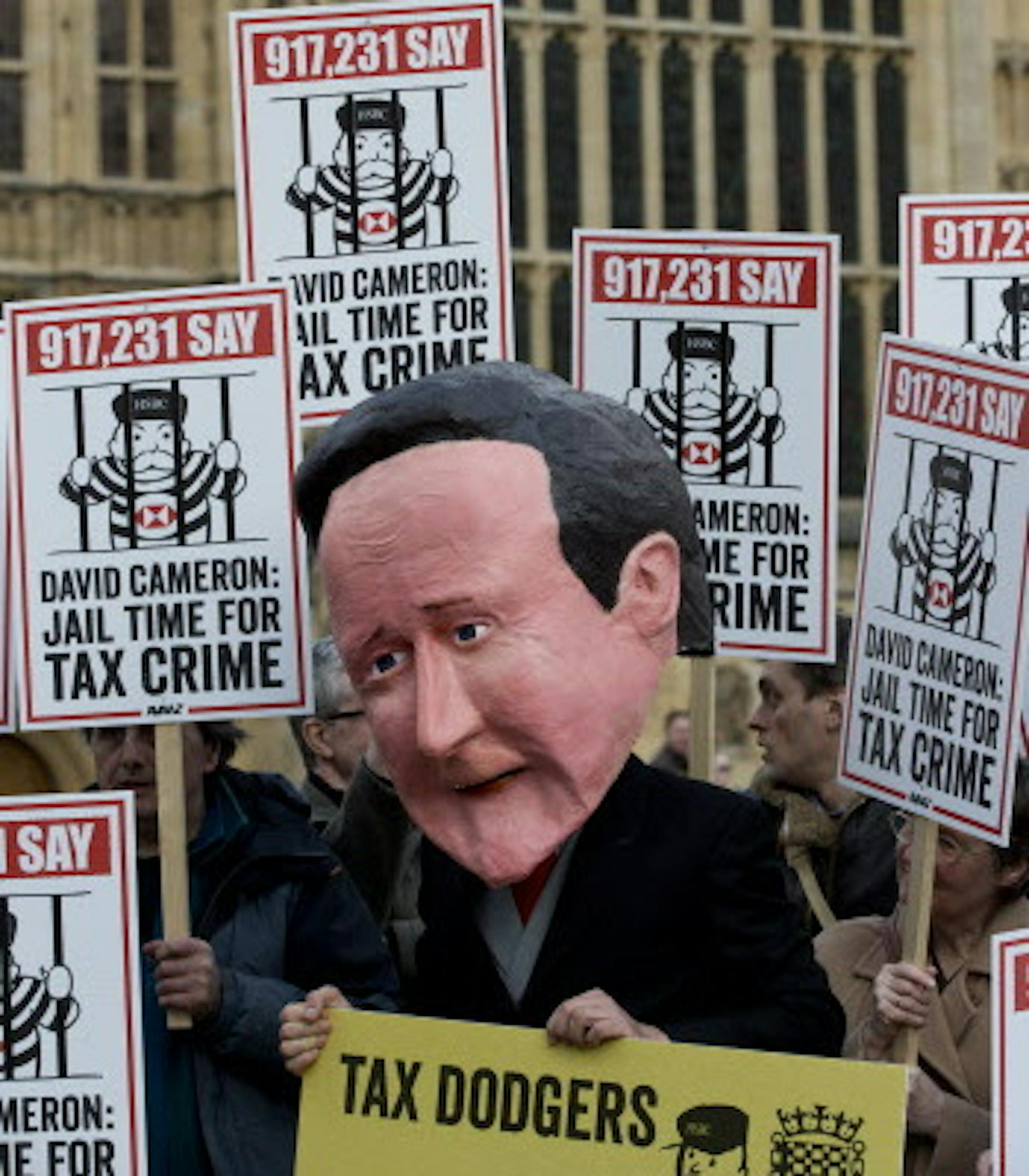 A protester wearing a large papier mache head of the British Prime Minister David Cameron takes part in demonstration against tax avoidance schemes operated by some British Banks, in London, Wednesday, Feb. 25, 2015. In Parliament Wednesday British lawmakers will talk to the HSBC Bank Chief executive Stuart Gulliver and chairman Douglas Flint about allegations that the banks Swiss HSBC private bank helped some people avoid paying tax.(AP Photo/Alastair Grant)