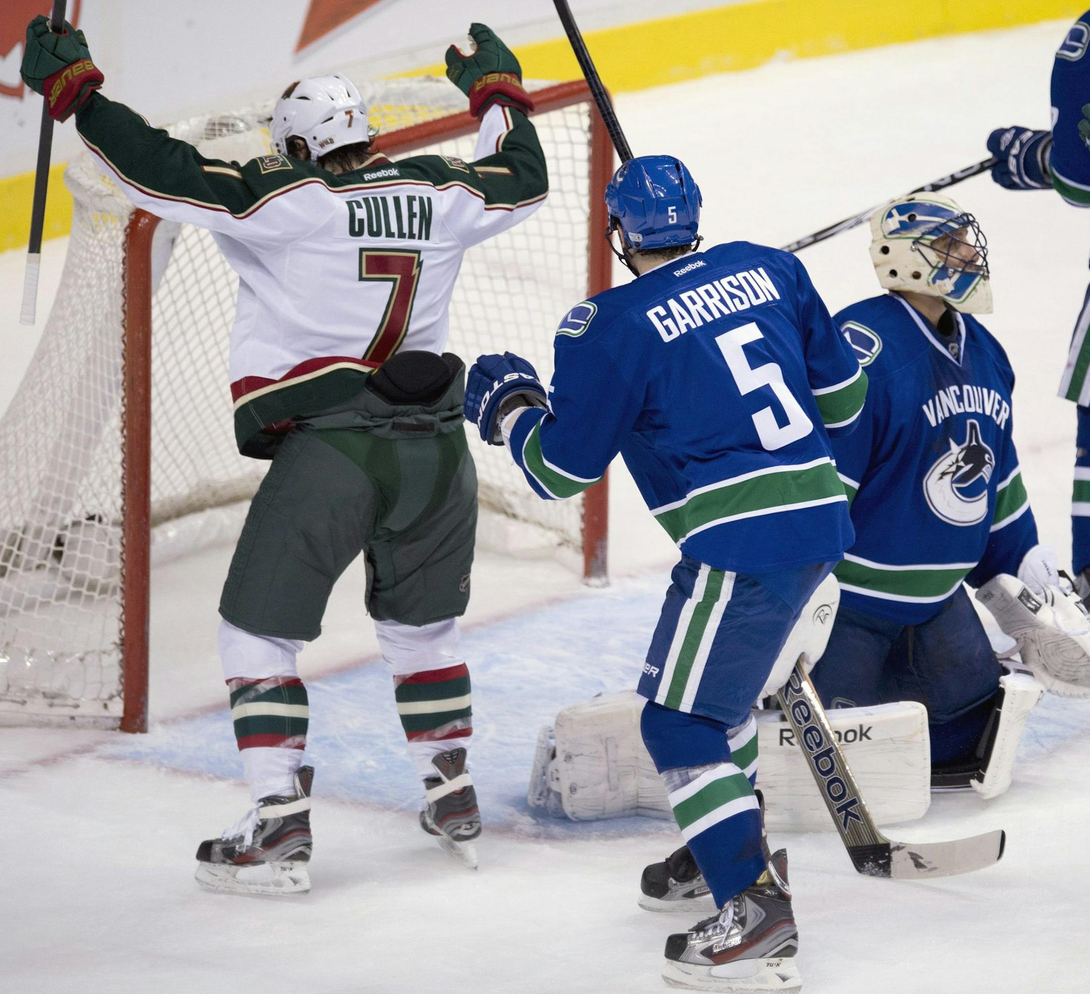 Minnesota Wild center Matt Cullen (7) celebrates teammate Jonas Brodin's goal past Vancouver Canucks goalie Roberto Luongo (1) as Vancouver Canucks defenseman Jason Garrison (5) looks on during second period NHL hockey action at Rogers Arena in Vancouver, British Columbia Monday, March,18, 2013. (AP Photo/The Canadian Press, Jonathan Hayward)