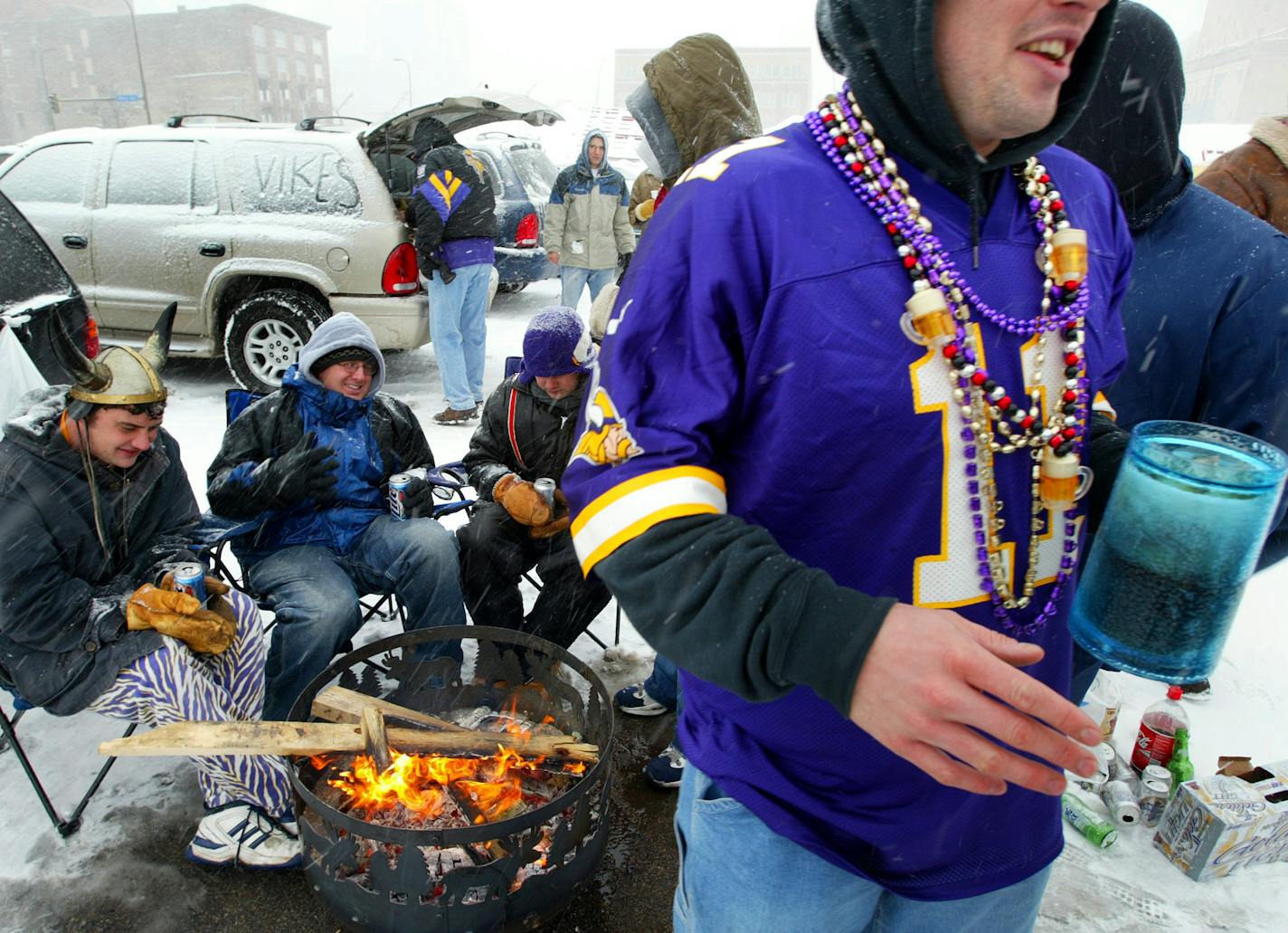 Steve Loos, Ryan Wagner and Mike Felien (all sitting left to right), buddies from Brooklyn Park, share a few beers around the fire in a parking lot along Washington Ave. Sunday morning before a Vikings game.