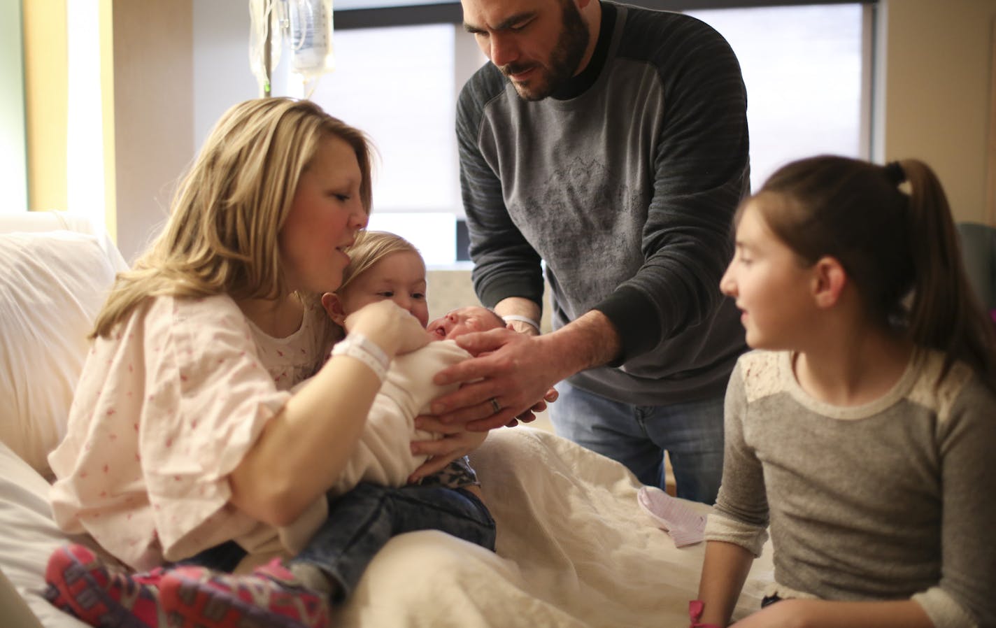 Willard Jedlicka placed his newborn son, Cash, in his daughter, Mila's arms so she could hold her brother for the first time. Mila is in her mom, Brianna's lap; at right is another daughter, Ava, in the birthing center at Methodist Hospital. Cash has three other older sisters that will help keep him in line as he grows up. ] JEFF WHEELER &#xef; jeff.wheeler@startribune.com Brianna Warner and her husband, Willard Jedlicka, scheduled the c-section birth of their son, Cash Willard Warner, for Leap