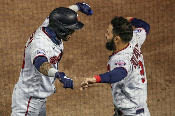 The Twins' Eddie Rosario, left, celebrates with Marwin Gonzalez, right, after hitting a solo home run off Cubs starting pitcher Alec Mills during the 