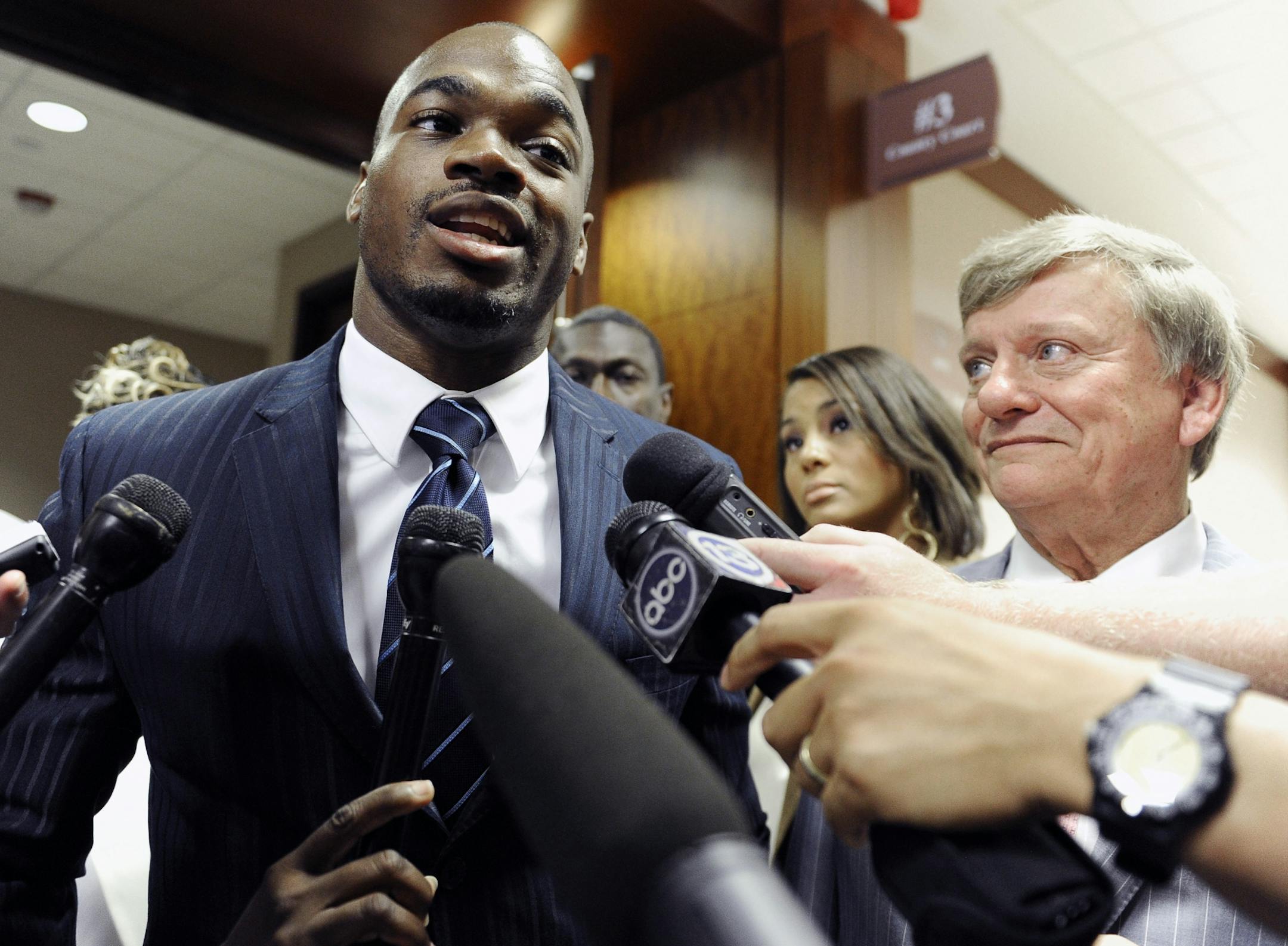 Minnesota Vikings running back Adrian Peterson, left, leaves a Houston courtroom with his attorney Rusty Hardin, Friday, July 13, 2012, in Houston. Peterson had a hearing set for August on charges of resisting arrest.