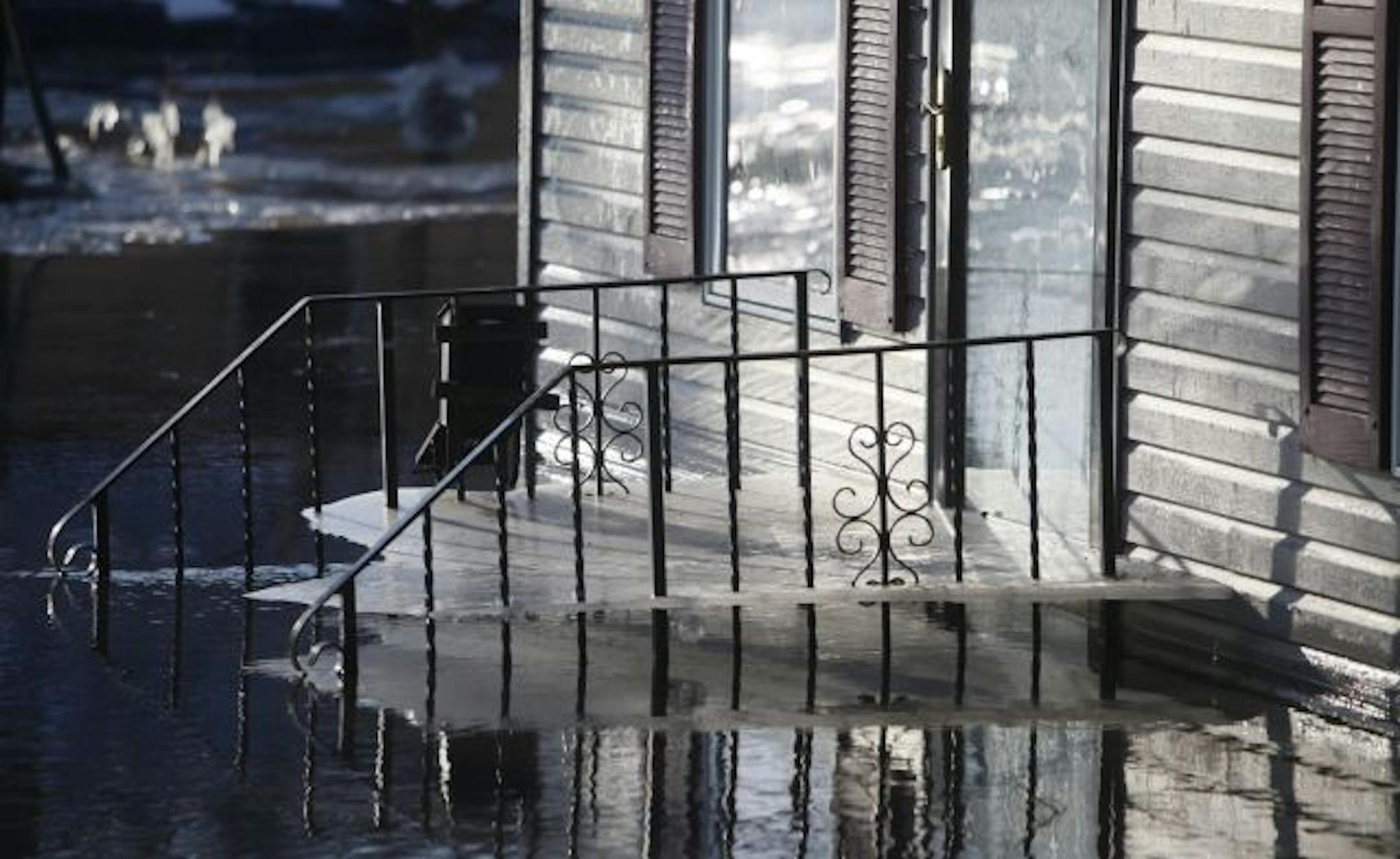 In the Oak Grove neighborhood, the frozen ice sheet on a door step shows evidence of where the water line was before the water level dropped off.