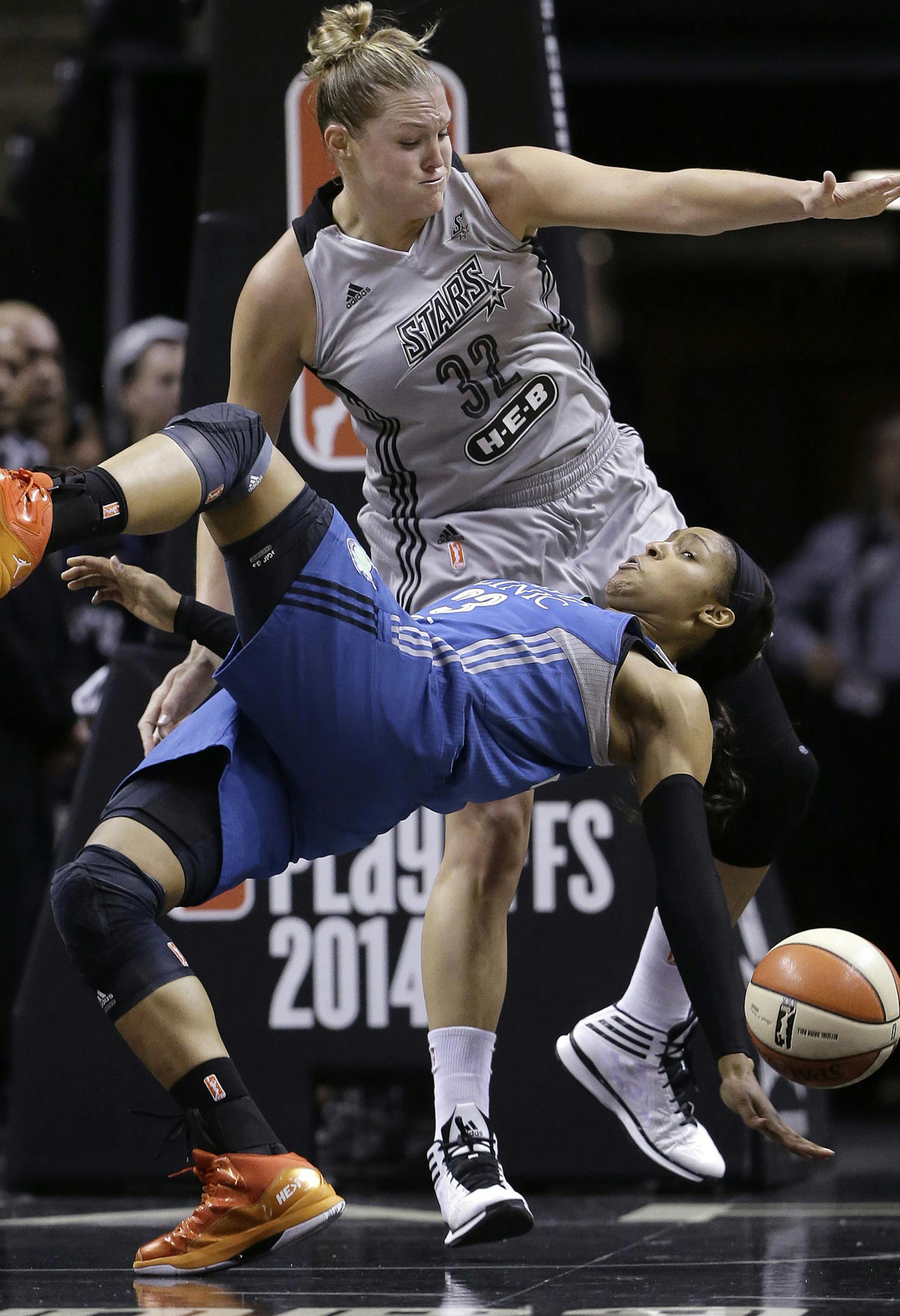 Minnesota Lynx's Maya Moore, front, falls to the court as she and San Antonio Stars' Jayne Appel battle for a rebound during the first half in Game 2 of the WNBA basketball Western Conference semifinal, Saturday, Aug. 23, 2014, in San Antonio. (AP Photo/Eric Gay)