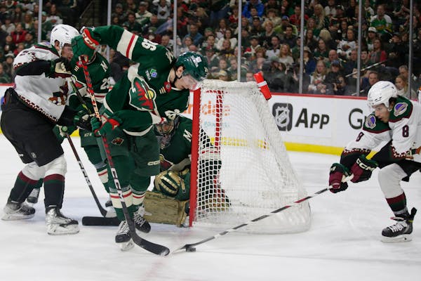 Arizona Coyotes center Nick Schmaltz (8) controls the puck in front of Minnesota Wild center Connor Dewar (26) during the second period of an NHL hock
