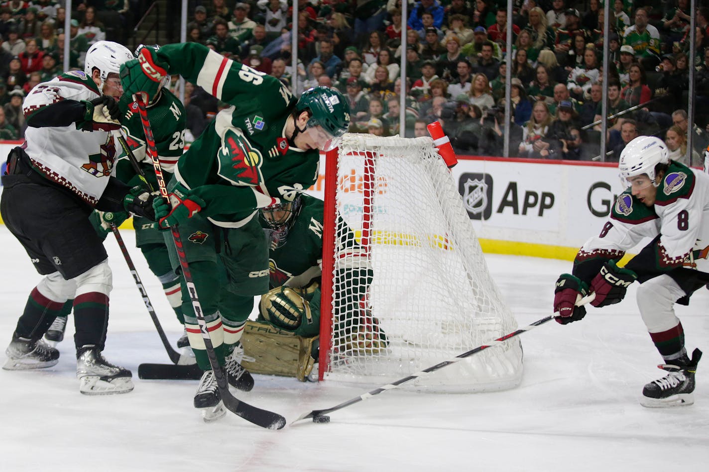 Arizona Coyotes center Nick Schmaltz (8) controls the puck in front of Minnesota Wild center Connor Dewar (26) during the second period of an NHL hockey game Saturday, Jan. 14, 2023, in St. Paul, Minn. (AP Photo/Andy Clayton-King)