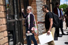 Kim’s bartender and server Kaylee Murphy, left, knocks on the door to the restaurant while delivering a petition to unionize with fellow employees o
