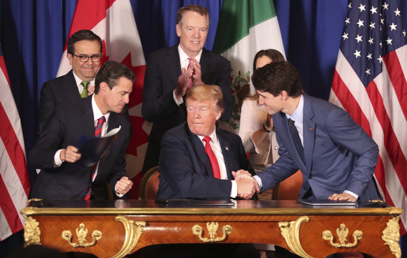 President Donald Trump, center, shakes hands with Canada's Prime Minister Justin Trudeau as Mexico's President Enrique Pena Nieto looks on after they signed a new United States-Mexico-Canada Agreement that is replacing the NAFTA trade deal, during a ceremony at a hotel before the start of the G20 summit in Buenos Aires, Argentina, Friday, Nov. 30, 2018. The USMCA, as Trump refers to it, must still be approved by lawmakers in all three countries. (AP Photo/Martin Mejia) ORG XMIT: XLM107