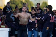 Washington Nationals second baseman Brian Dozier stands shirtless at a rally after a parade to celebrate the team's World Series baseball championship