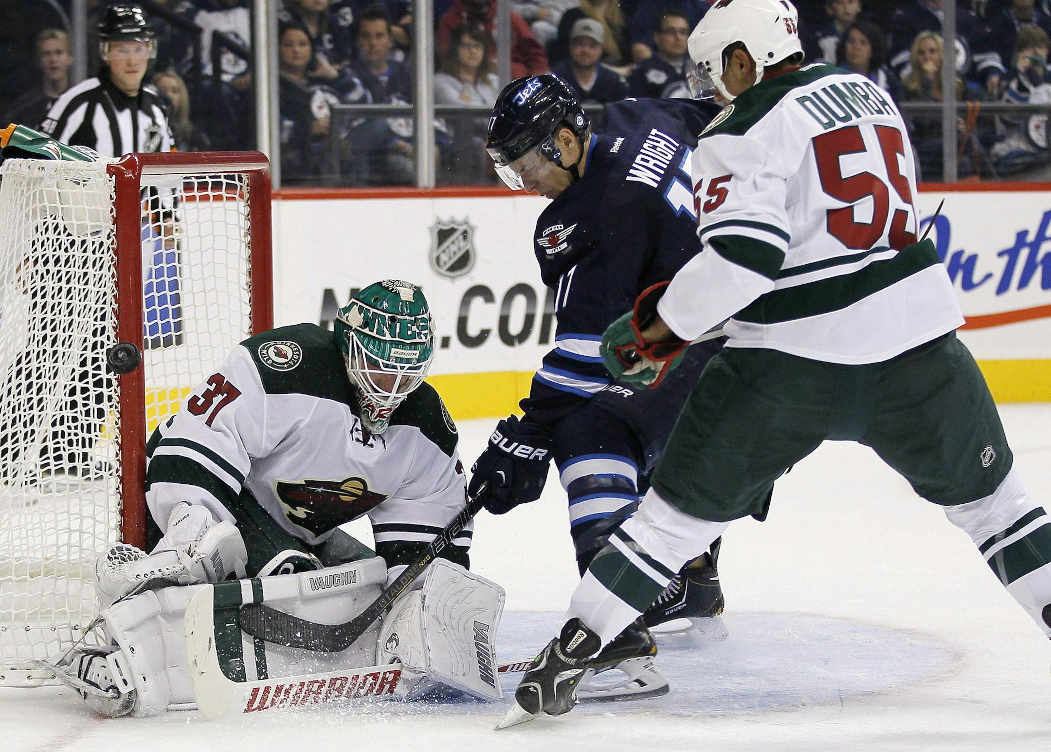 Minnesota Wild goaltender Josh Harding (37) gets his pad on a shot from Winnipeg Jets' James Wright (17) as Wild's Mathew Dumba (55) watches for the rebound during second-period preseason NHL hockey game action in Winnipeg, Manitoba, Thursday, Sept. 19, 2013. (AP Photo/The Canadian Press, John Woods) ORG XMIT: MIN2013092617034787 ORG XMIT: MIN1309261706363871