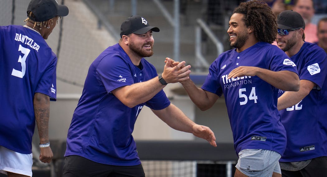 Harrison Phillips celebrates with Eric Kendricks during Adam Thielen’s charity softball game at CHS Field in May.