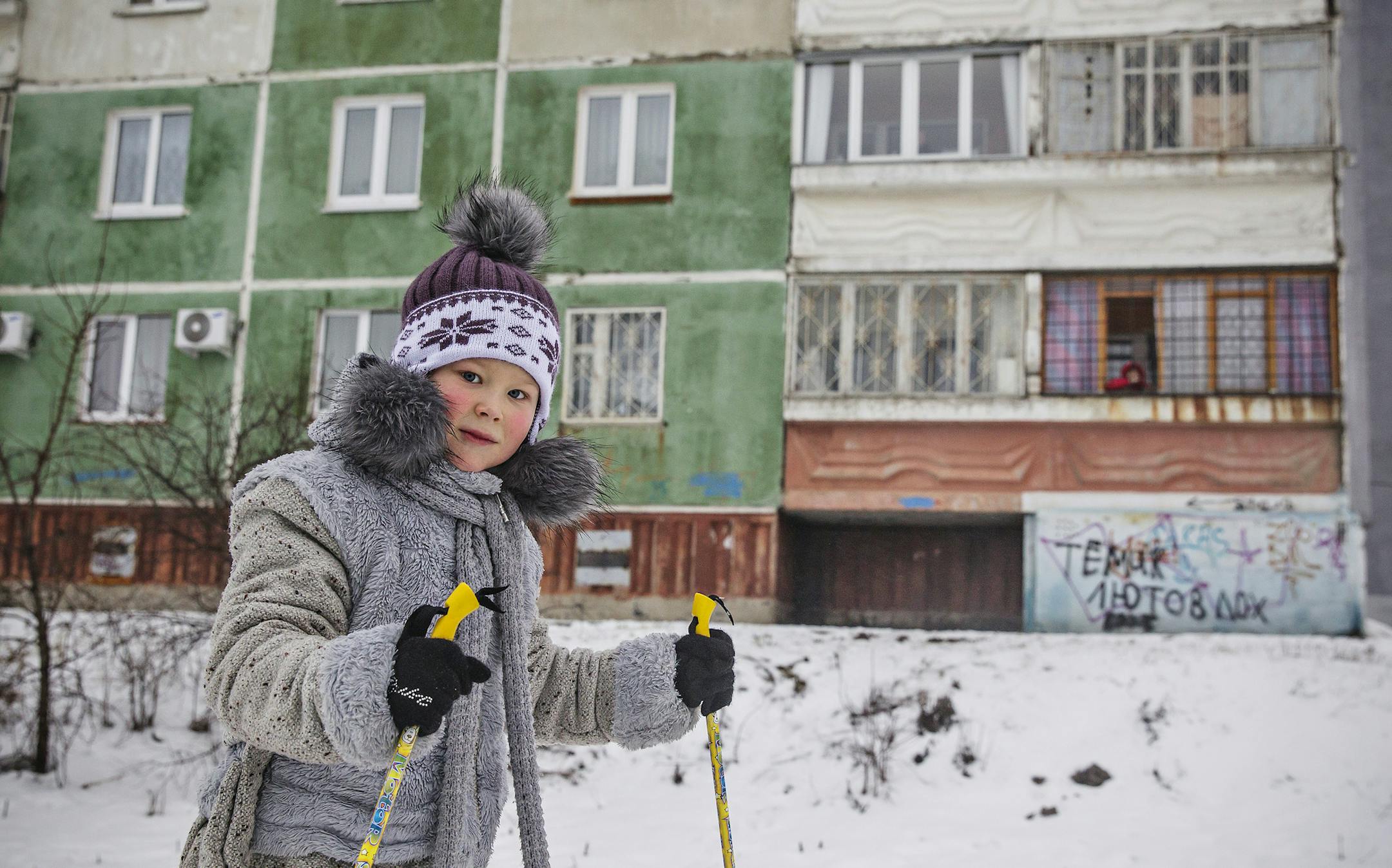 Small girl tries skiing on a sidewalk in front of typical blocks of flats neighbourhood in Nizhny Novgorod, which is with it's 1,28 millions inhabitants the fourth biggest city in Russia. The city was known as Gorky between 1932 to 1990, as it was re-named after the writer Maxim Gorky. The city is an important economic, transportation and cultural centre of Russia and the vast Volga-Vyatka economic region. Nizhny Novgorod is seat of the biggest Russian car producing company GAZ, part of there GA