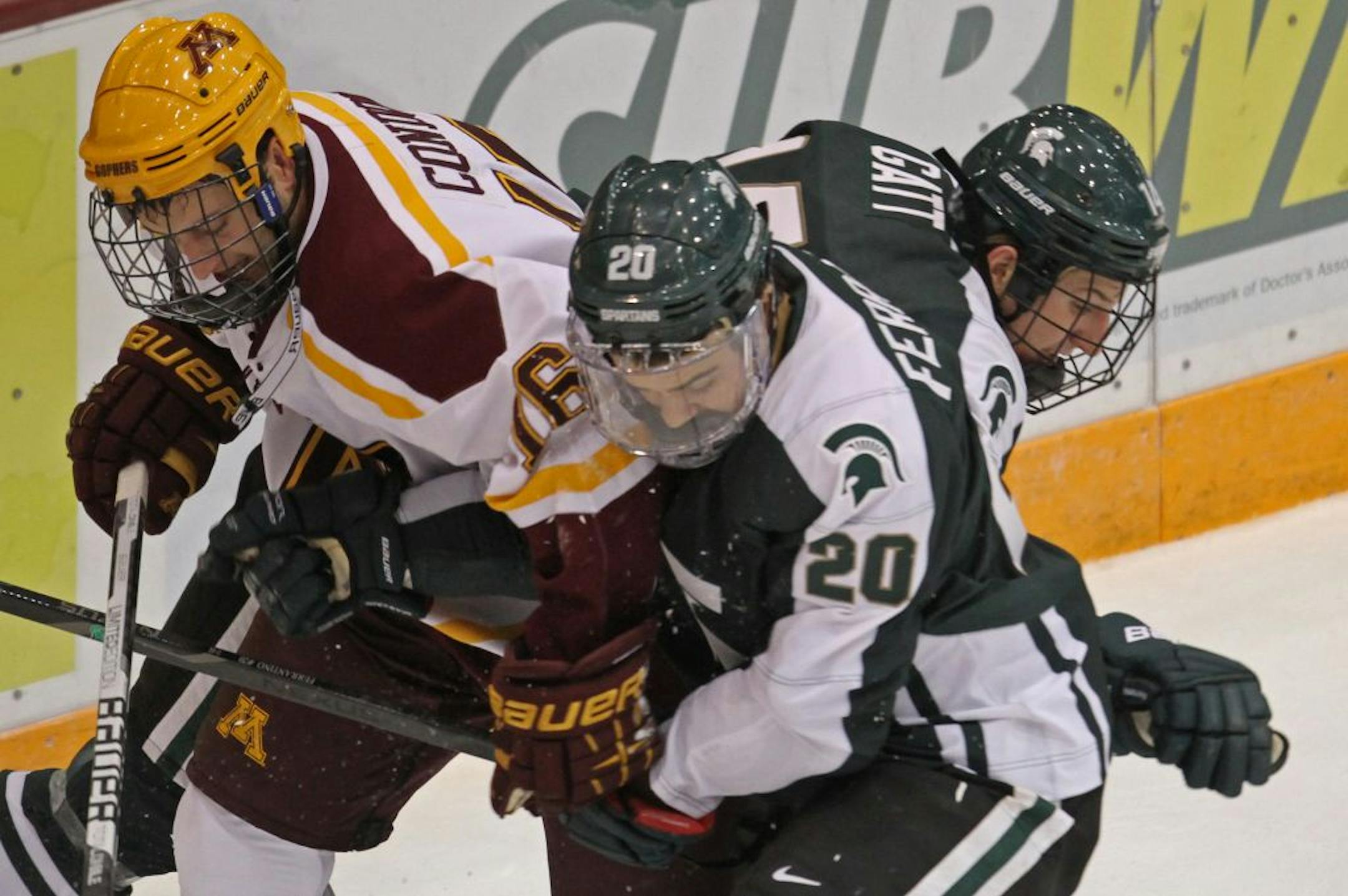Minnesota's Nate Condon, Michigan State's Michael Ferrantino and Nickolas Gatt fought for control of the puck.