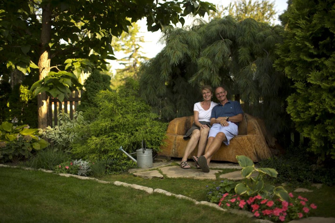 A "sofa" carved from a tree killed by Dutch elm disease is one of the many focal points in the enchanted Edina garden of Rosanne and Steve Malevich. The sofa is tucked unto a nook made by a towering arborvitae, a weeping white pine and two large catalpa trees.