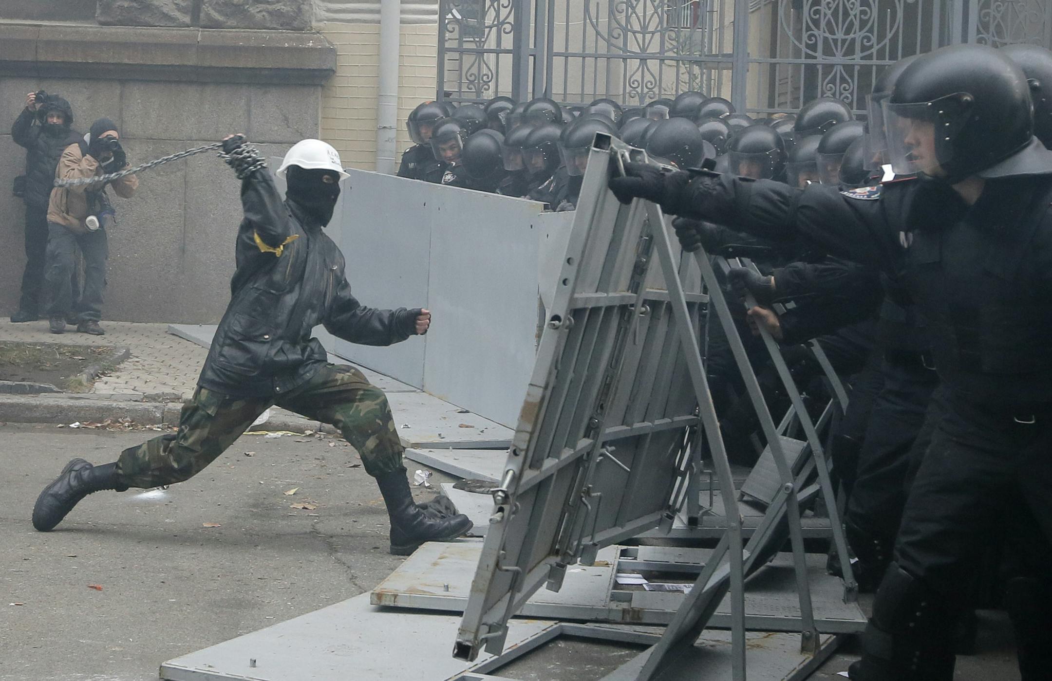 Protesters clash with police outside the presidential office in Kiev, Ukraine, on Sunday, Dec. 1, 2013. A protest by about 300,000 Ukrainians angered by their government's decision to freeze integration with the West turned violent Sunday, when a group of demonstrators besieged the president's office and police drove them back with truncheons, tear gas and flash grenades. Dozens of people were injured. The mass rally in central Kiev defied a government ban on protests on Independence Square, in