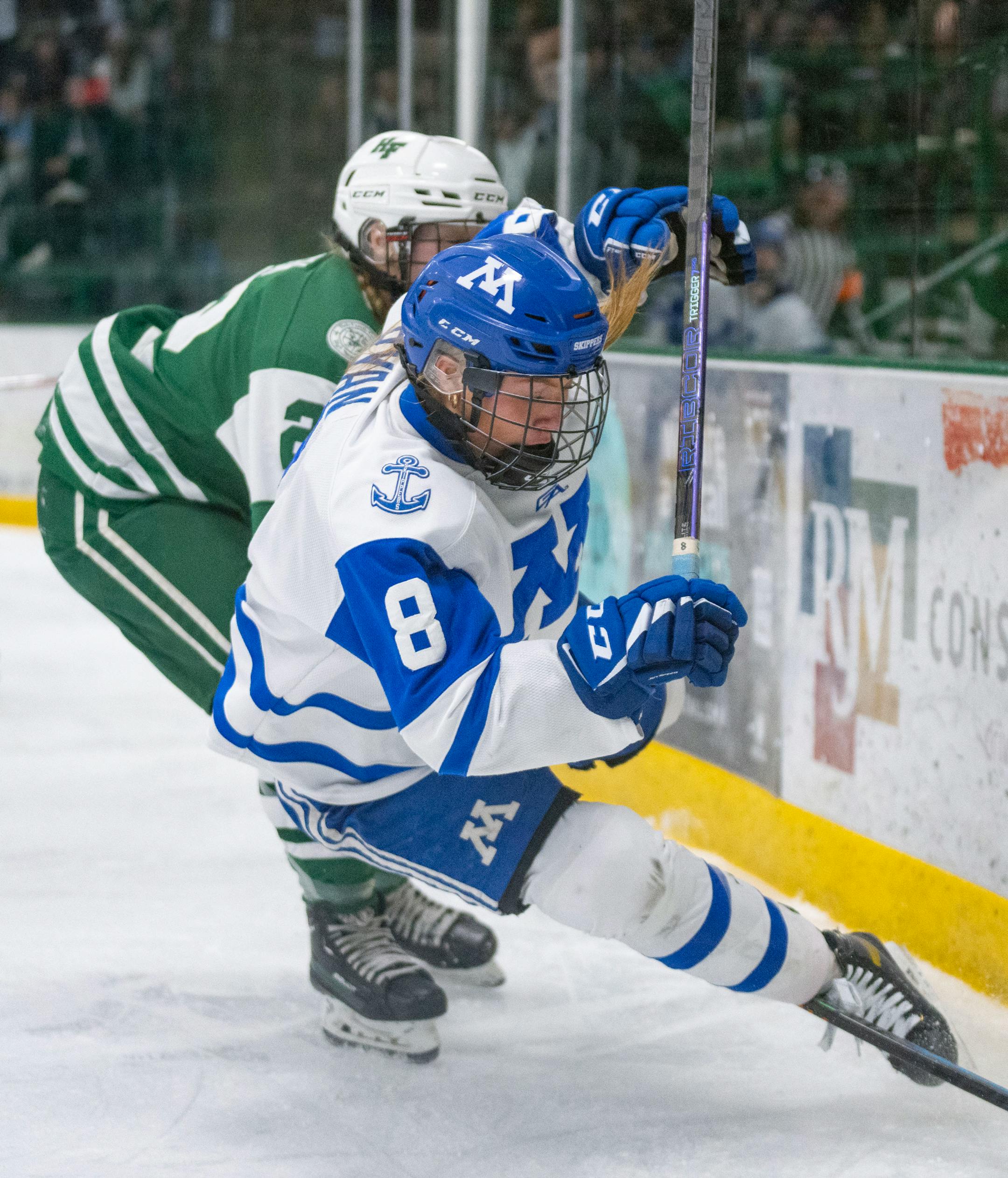 Holy Family defender Olivia Paidosh (22) trips Minnetonka forward Molly Ryan (8) during the second period.