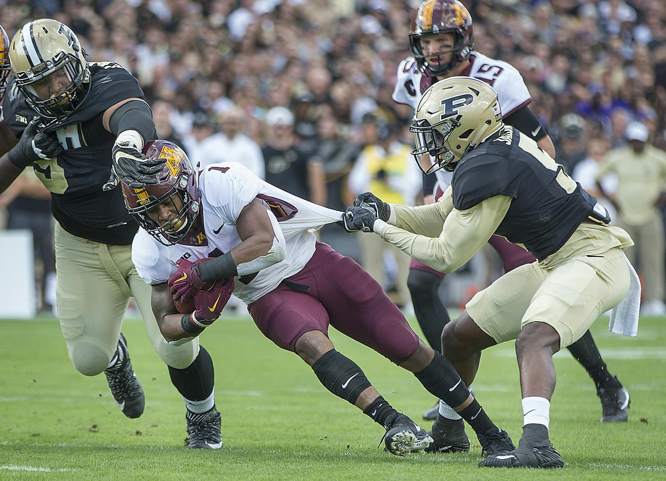 Minnesota's running back Rodney Smith plowed through Purdue defense including Lorenzo Neal, left, and safety T.J. Jallow during the first quarter the Gophers took on Purdue at Ross-Ade Stadium, Saturday, October 7, 2017 in West Lafayette, IN.