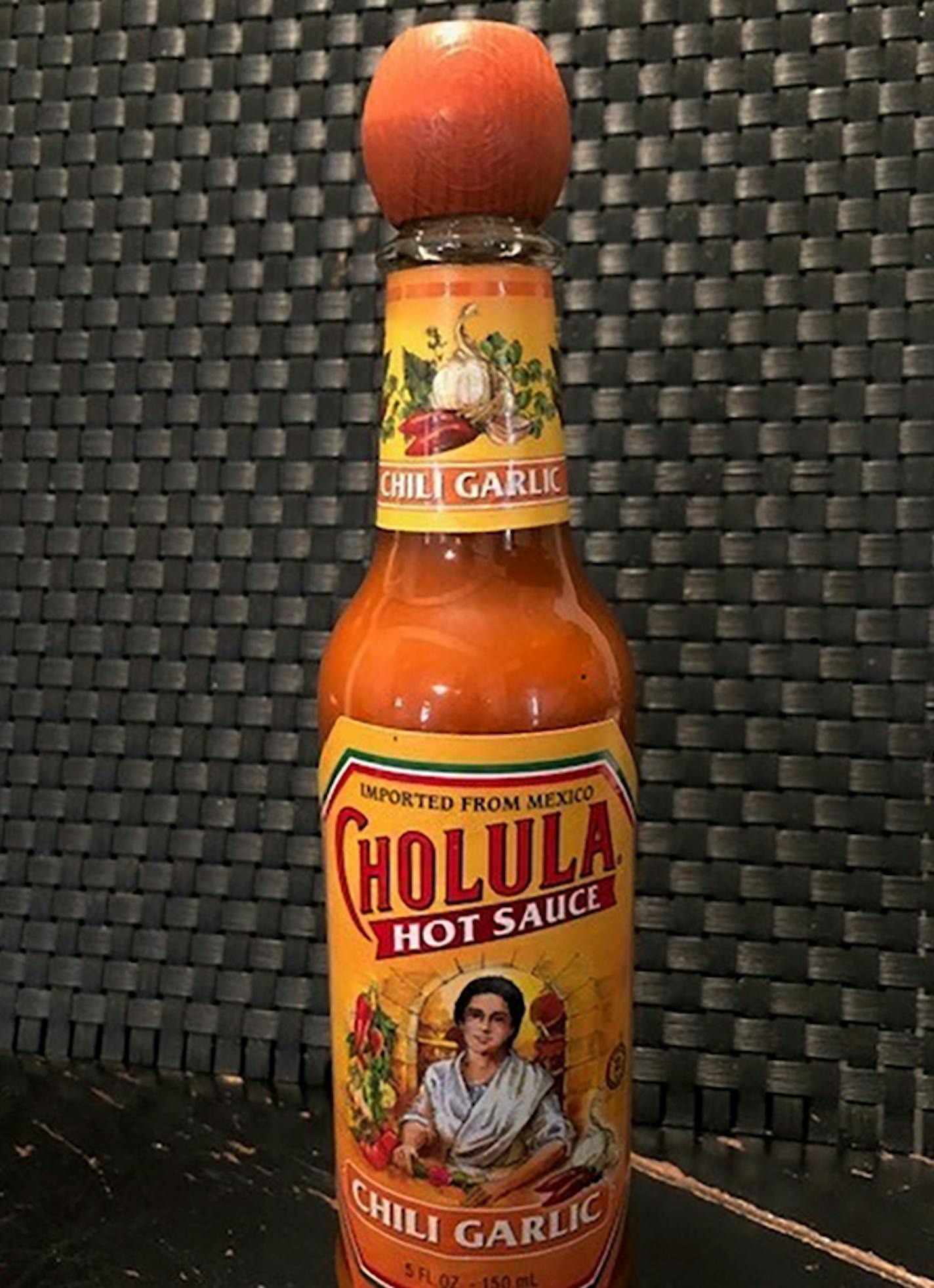 This Tuesday Nov. 24, 2020 photo shows a bottle of Cholula Hot Sauce. Spice maker McCormick & Co. is buying the parent of Cholula Hot Sauce from private-equity firm L Catteron for $800 million, expanding its reach in the hot sauce category. That deal included French's mustard and Frank's RedHot brands. The company views the addition of Cholula as a way to appeal to millennials, a group that has a particular liking for the hot sauce. (AP Photo/Charles Sheehan)