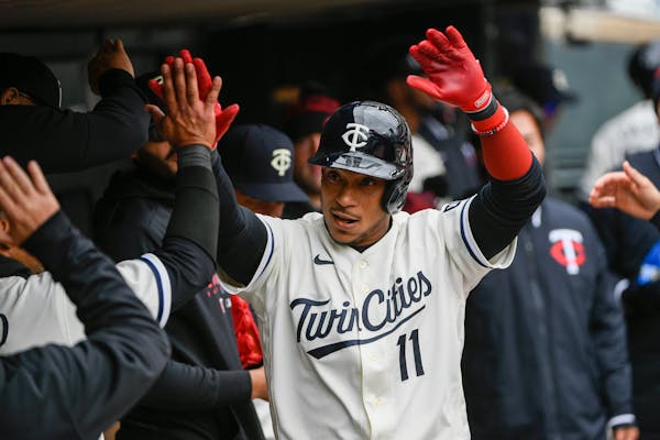Minnesota Twins' Jorge Polanco celebrates in the dugout after hitting a home run against Washington Nationals pitcher Patrick Corbin during the fourth