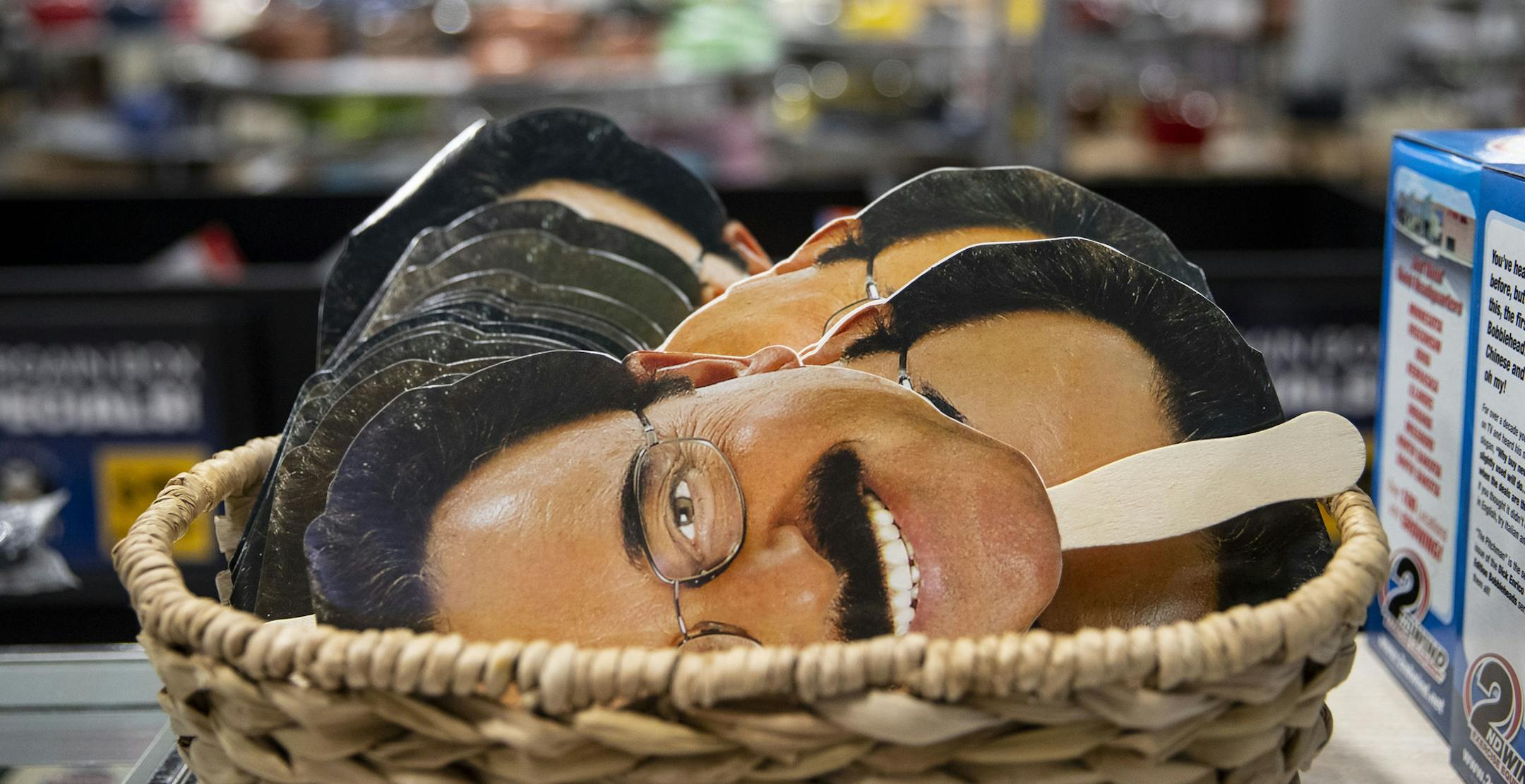Enrico photo masks of his face sit in a small basket in the front of his store.