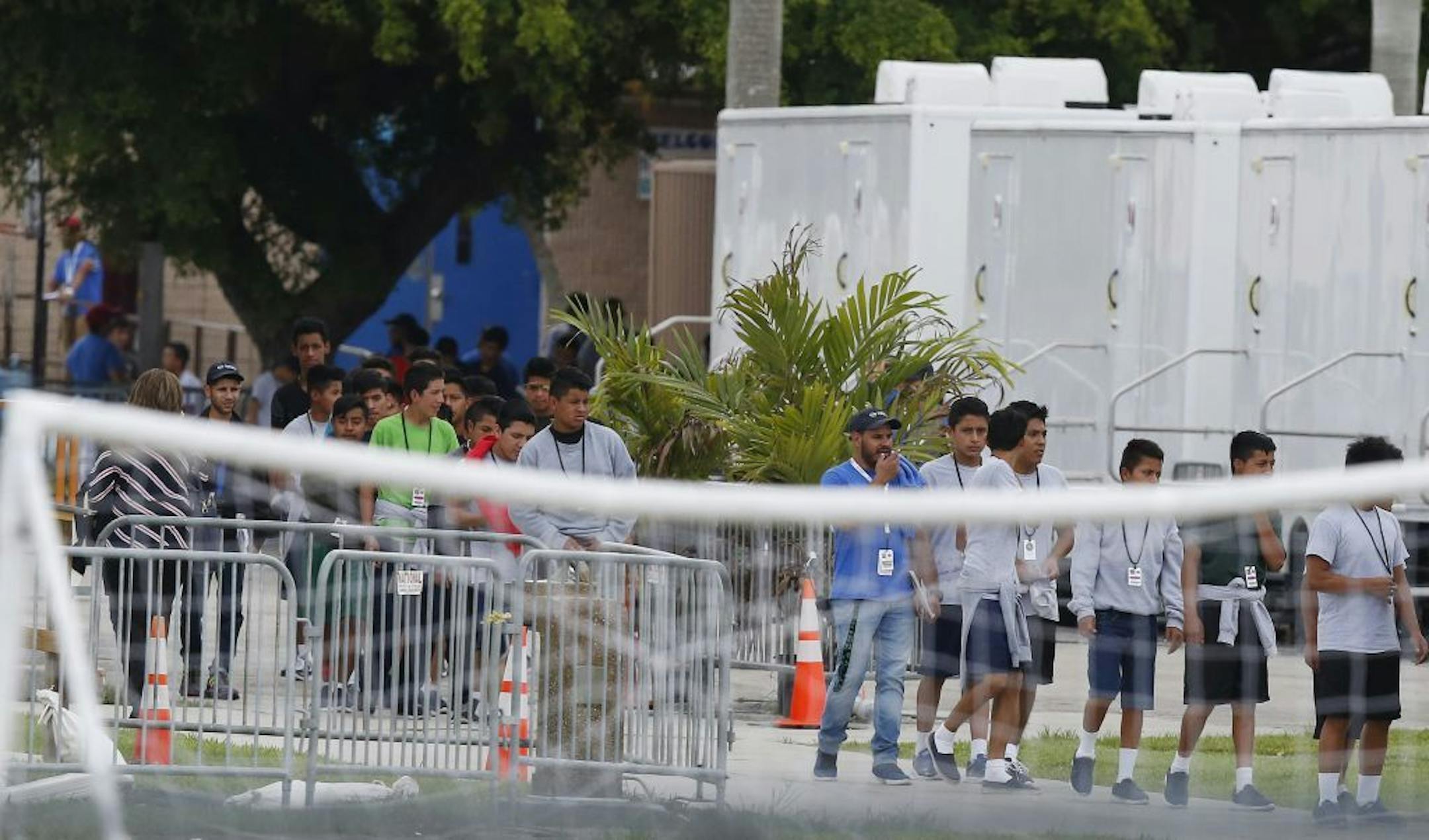 Immigrant children walk in a line outside the Homestead Temporary Shelter for Unaccompanied Children, a former Job Corps site that now houses them, on Wednesday, June 20, 2018, in Homestead, Fla. U.S. Rep. Carlos Curbelo said he found it "troubling" to see two of his Democratic colleagues turned away from the Miami-area detention center for migrant children.