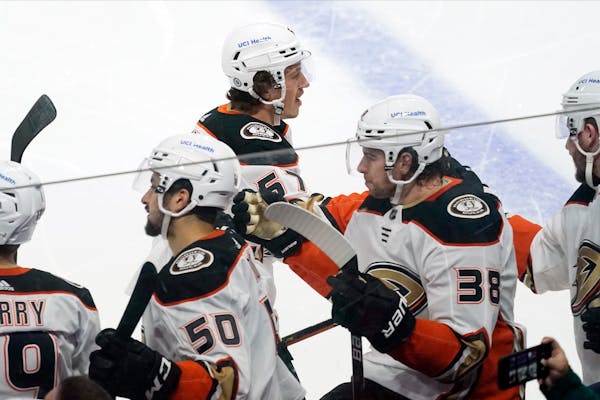 Anaheim Ducks' Rickard Rakell, center, is congratulated at the bench after scoring against the Minnesota Wild during the first period of an NHL hockey