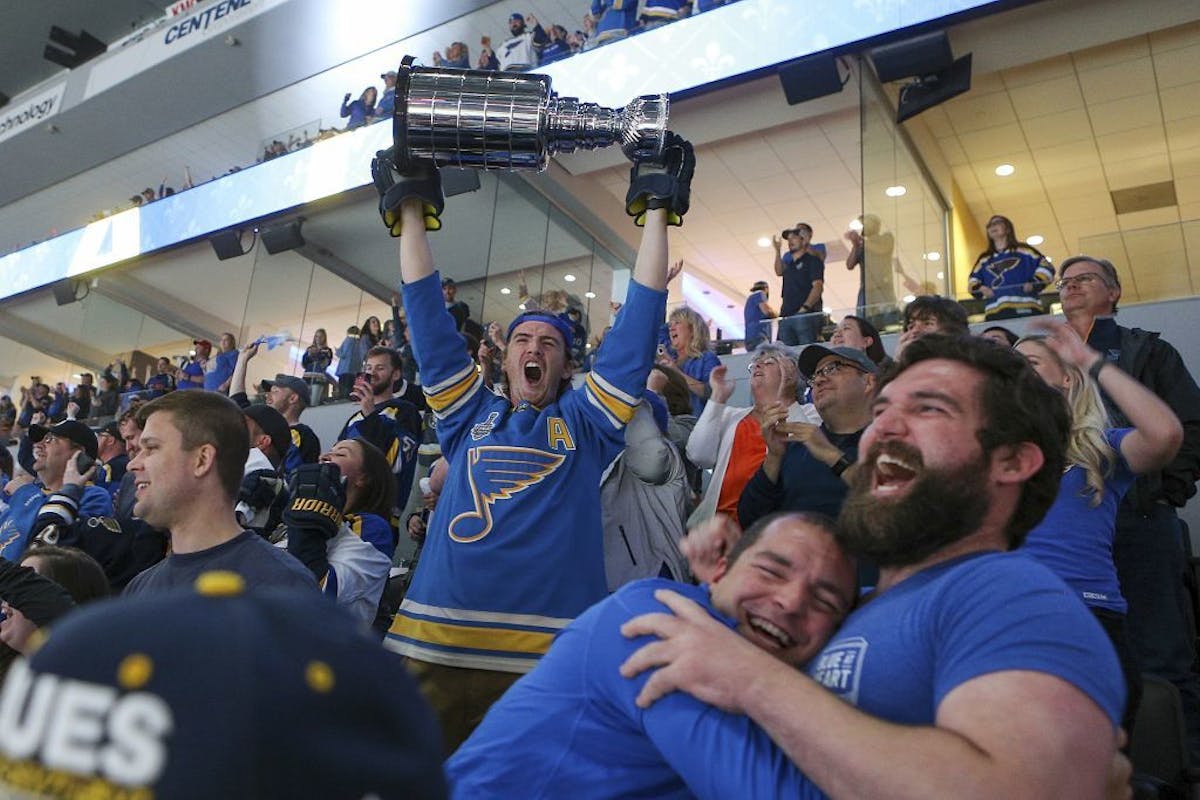 A St. Louis Blues fan at a hoists a replica Stanley Cup in celebration at a watch party in the Enterprise Center in St. Louis after the Blues scored a