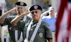 Vietnam Veterans of America Chapter 522 and Color Guard members, Mike Boucher (center), 66, salutes along with Brian Keane, 73, both from Palm Harbor,