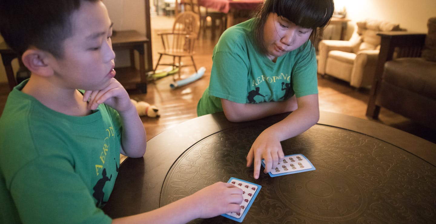 Pahnuly Xiong plays a card game with her brother Kusa that he invented. ] LEILA NAVIDI &#xef; leila.navidi@startribune.com BACKGROUND INFORMATION: At home with the Xiong family in Brooklyn Park on Tuesday, January 9, 2018. Fifth grader Kusa Xiong wanted to find a way for his autistic sister to play and enjoy his favorite game: ping pong. Known as a kid inventor, Xiong ended up creating an entirely new, ping pong-style toy called Aeropong. His idea has captured national accolades in a contest and