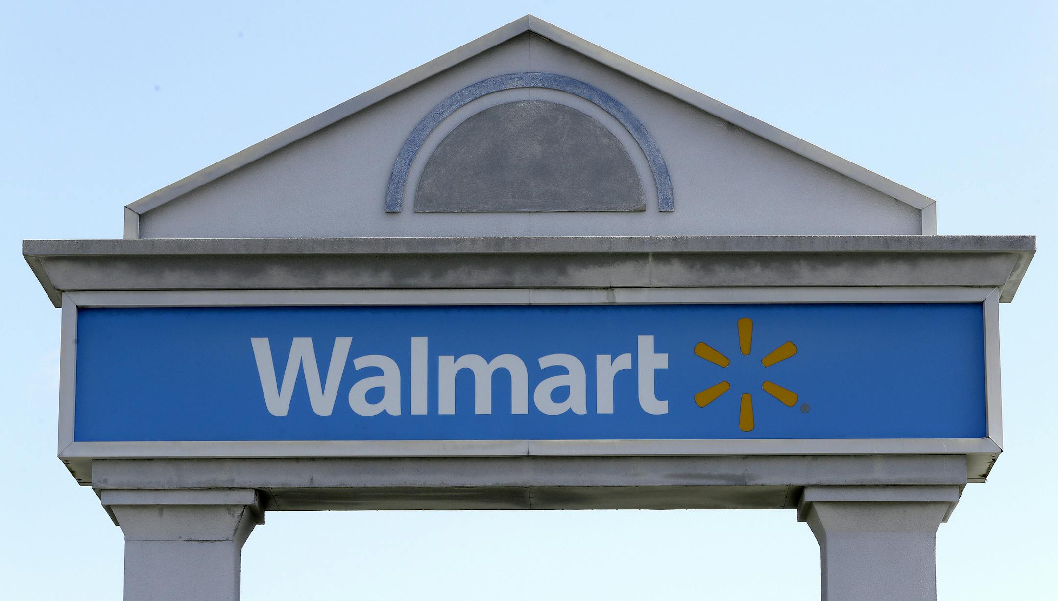 A Walmart logo forms part of a sign outside a Walmart store, Tuesday, Sept. 3, 2019, in Walpole, Mass. Walmart is going back to its folksy hunting heritage and getting rid of anything that's not related to a hunting rifle after two mass shootings in its stores in one week left 24 people dead in August of 2019. (AP Photo/Steven Senne)
