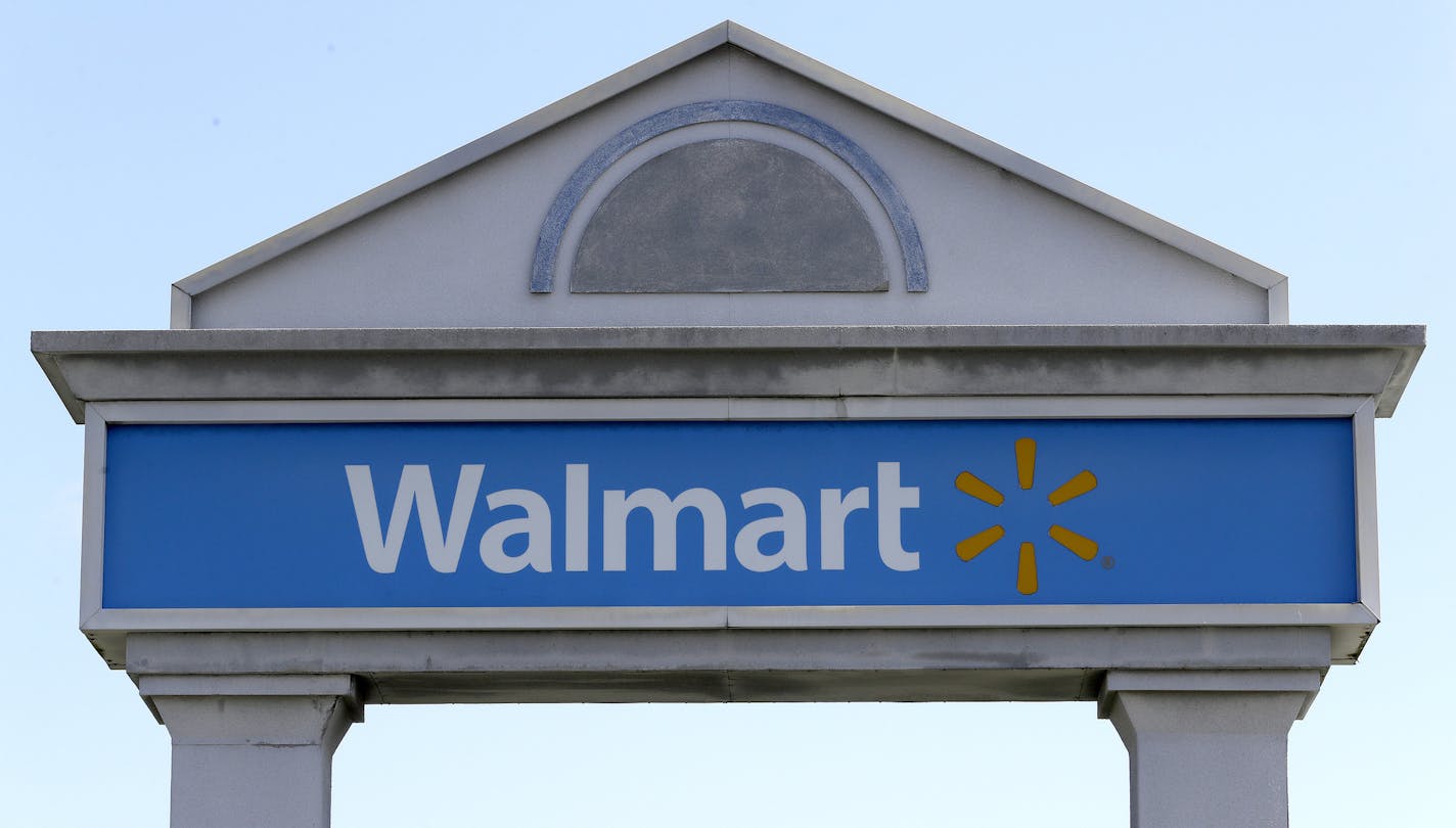 A Walmart logo forms part of a sign outside a Walmart store, Tuesday, Sept. 3, 2019, in Walpole, Mass. Walmart is going back to its folksy hunting heritage and getting rid of anything that's not related to a hunting rifle after two mass shootings in its stores in one week left 24 people dead in August of 2019. (AP Photo/Steven Senne)