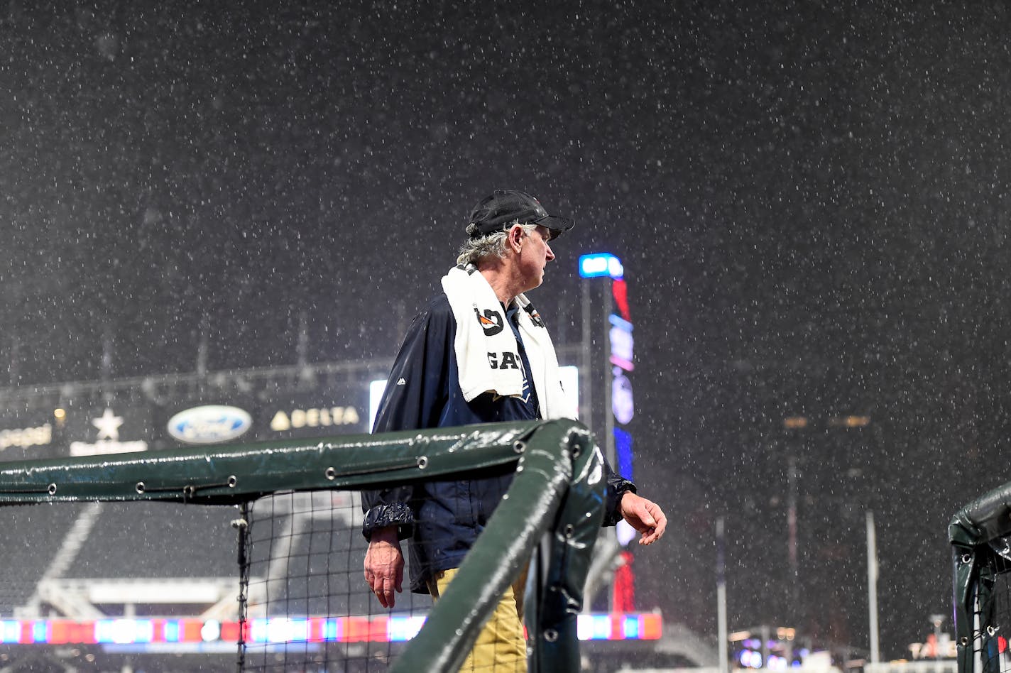 Larry Divito, head grounds keeper for the Minnesota Twins, looks over the field during a rain delay that interrupted their game against the Houston Astros after the third inning of a baseball game, Wednesday, May 11, 2022, in Minneapolis. (AP Photo/Craig Lassig)