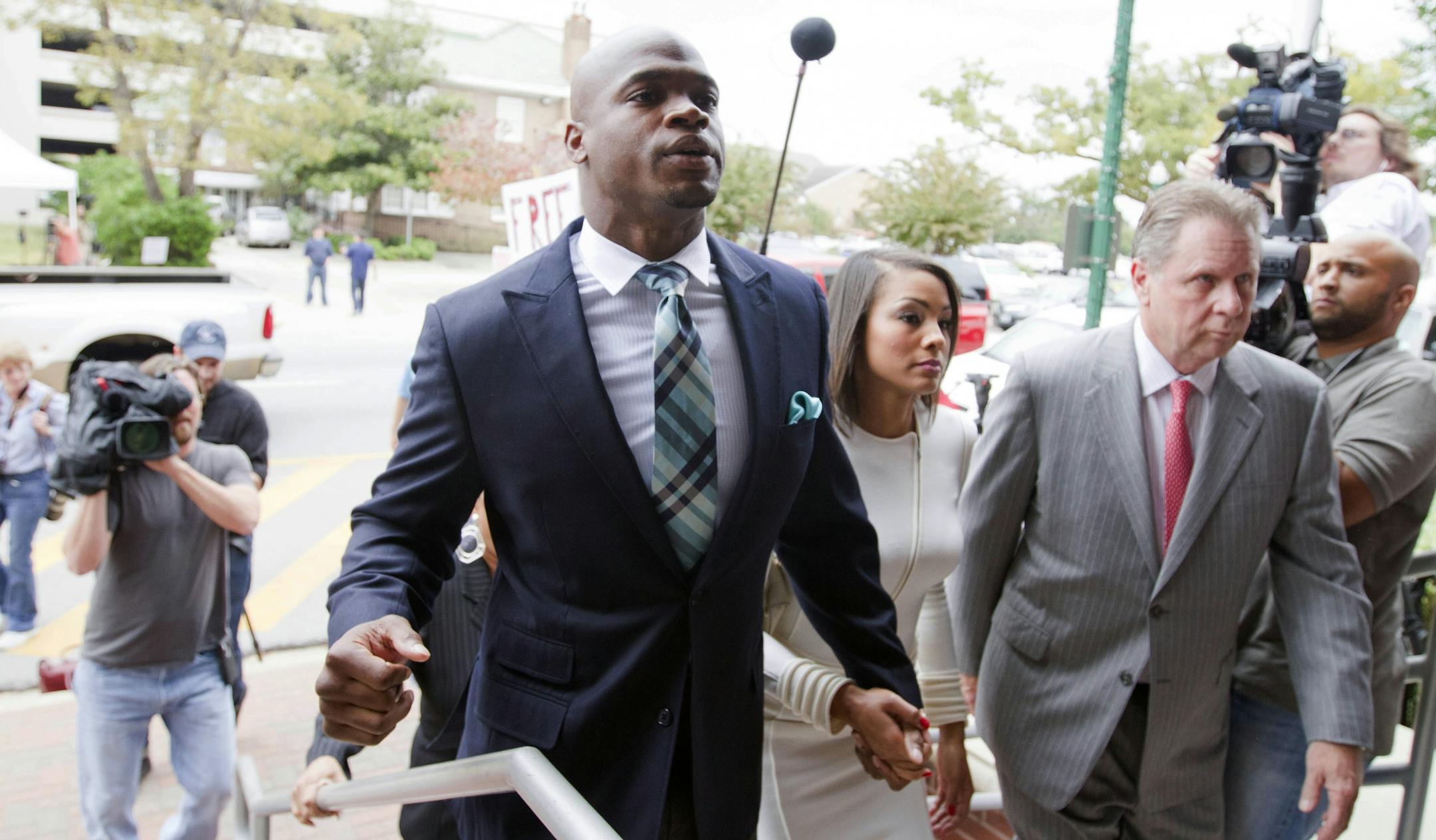 Minnesota Vikings running back Adrian Peterson arrives at the courthouse with his wife Ashley Brown Peterson, for an appearance Tuesday, Nov. 4, 2014, in Conroe, Texas. Minnesota Vikings star Adrian Peterson avoided jail time on Tuesday in a plea agreement reached with prosecutors to resolve his child abuse case. (AP Photo/ The Courier, Jason Fochtman) MANDATORY CREDIT
