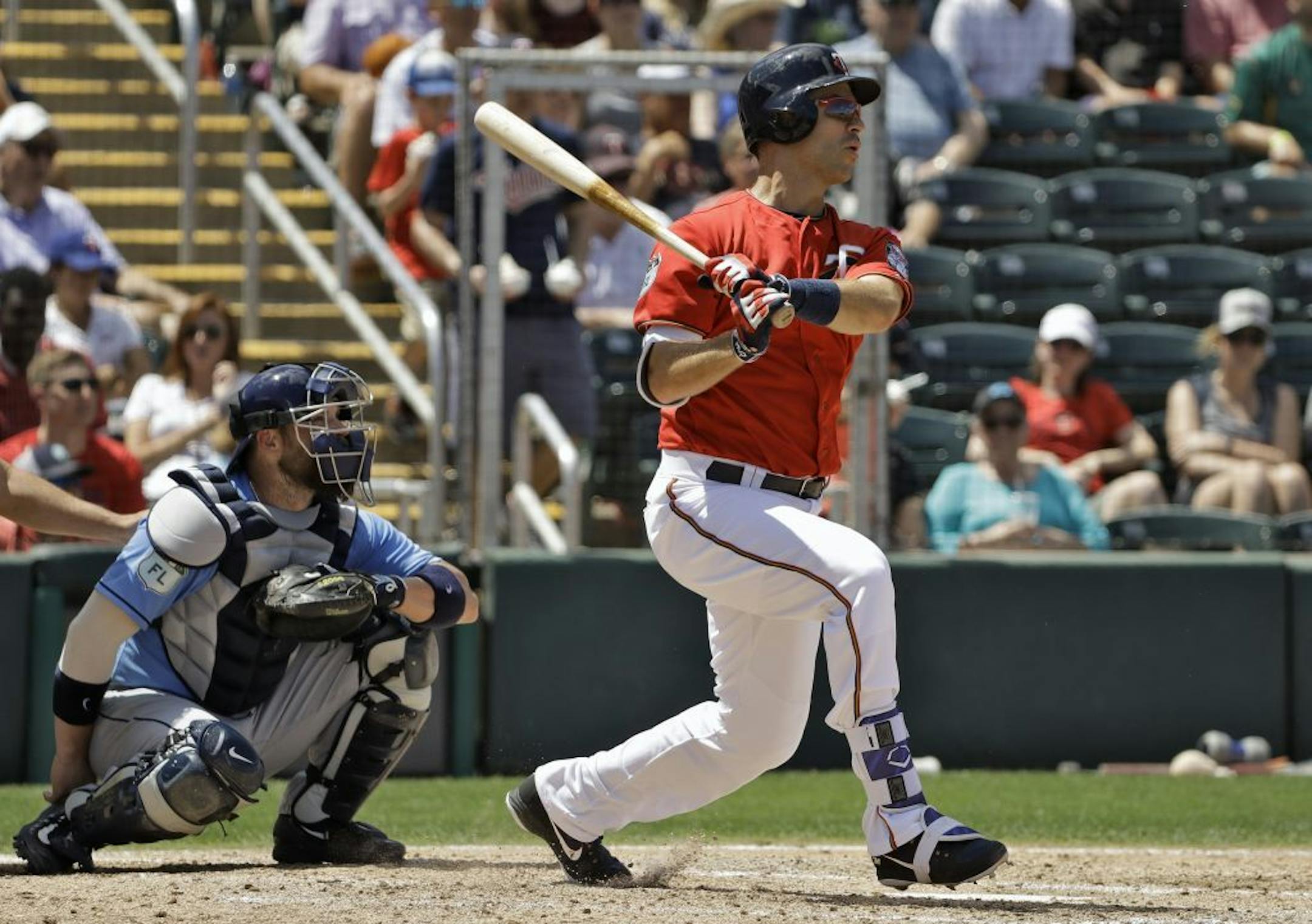 Minnesota Twins' Joe Mauer follows the flight of his double off Tampa Bay Rays relief pitcher Danny Farquhar during the fourth inning of a spring training baseball game Tuesday, March 28, 2017, in Fort Myers, Fla. Catching for the Rays is Derek Norris.