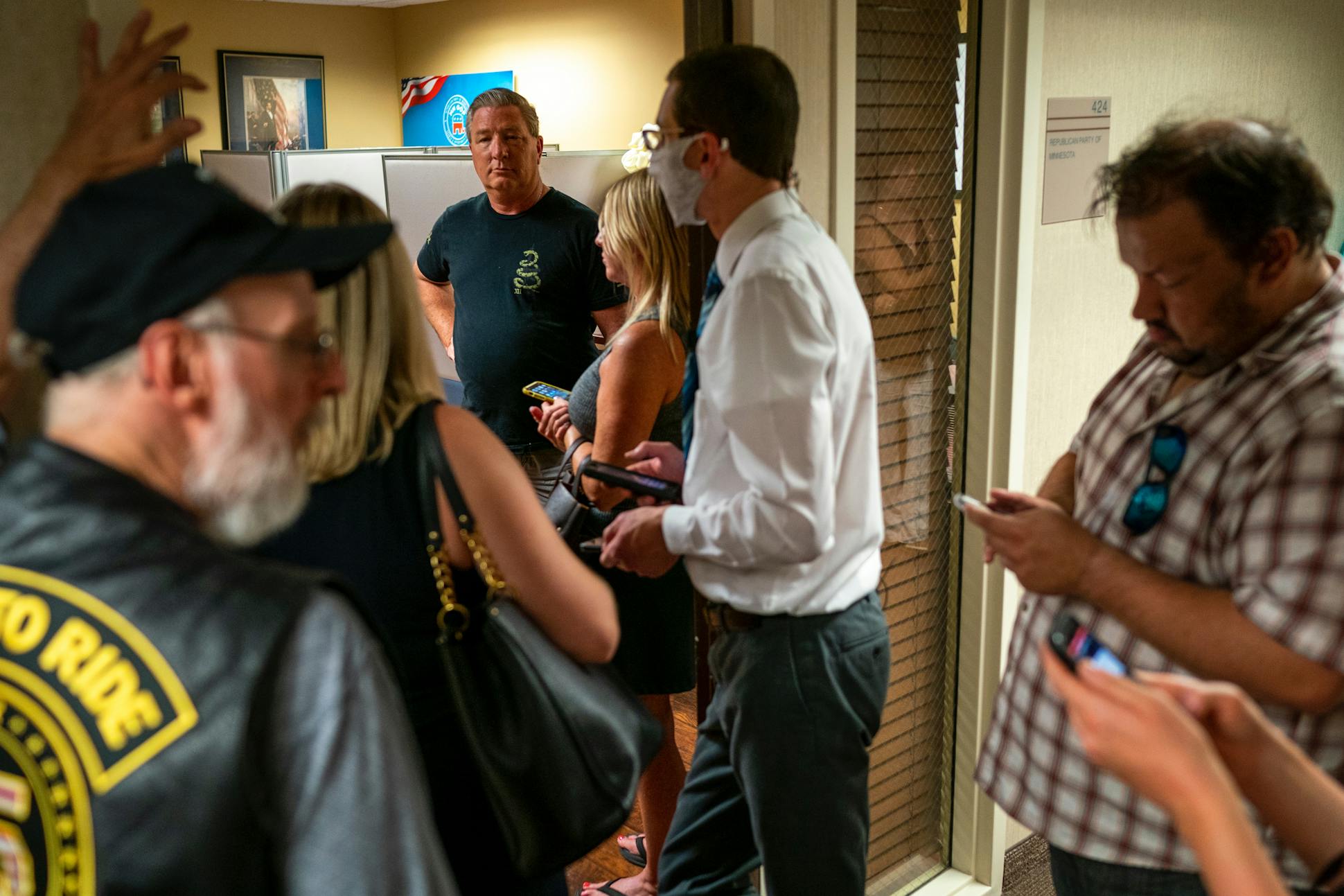 Mike Smith, center, along with a group of protestors and media, wait outside the meeting room of the Republican Party of Minnesota as the party's executive board met to force out Jennifer Carnahan as state party chair on Aug. 19, 2021, in Edina.