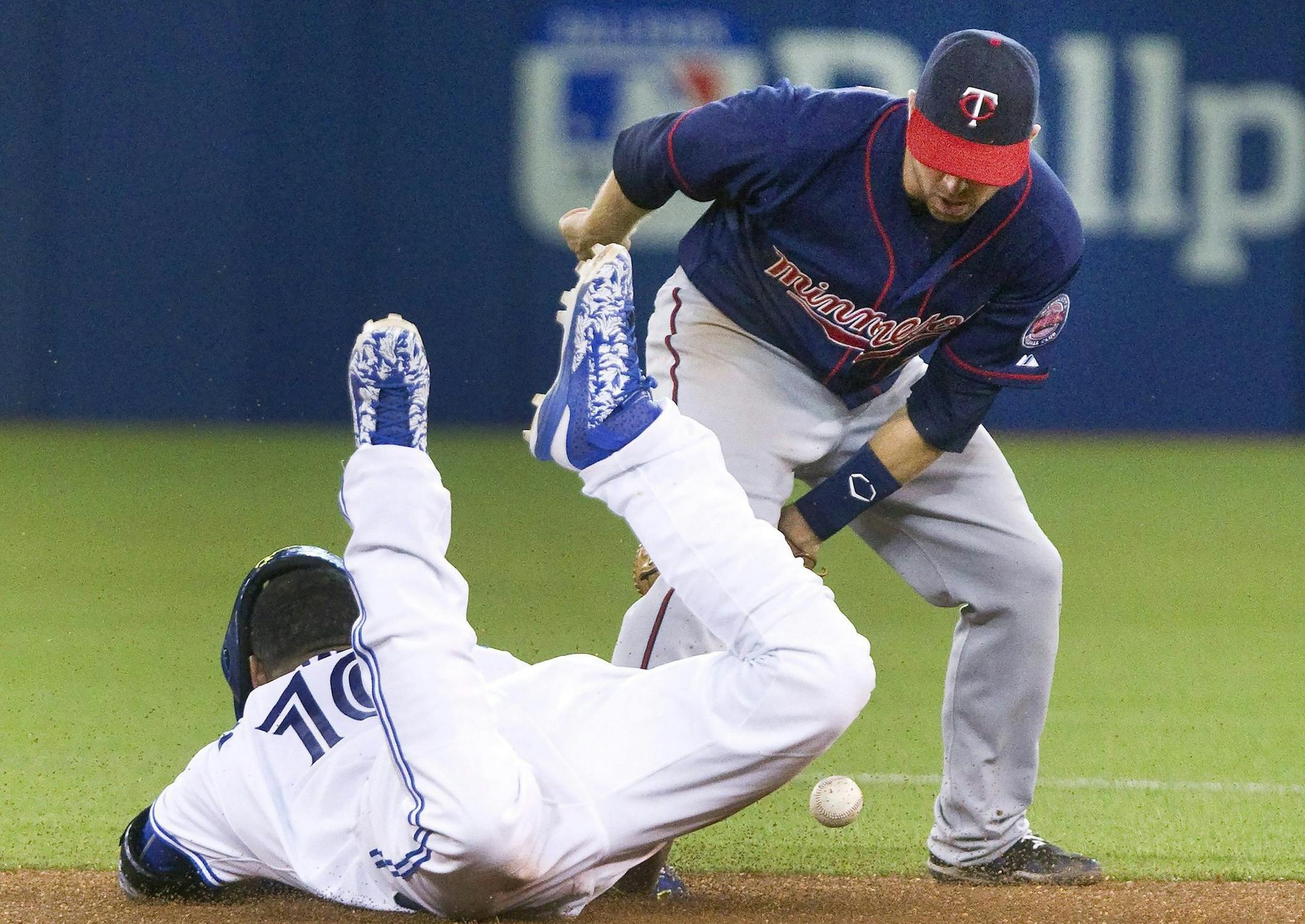 Toronto Blue Jays' Edwin Encarnacion, left, slides safely into second with a double as Minnesota Twins Brian Dozier bobbles the throw during the sixth inning of a baseball game, Tuesday, Aug. 4, 2015 in Toronto. (Fred Thornhill/The Canadian Press via AP) MANDATORY CREDIT