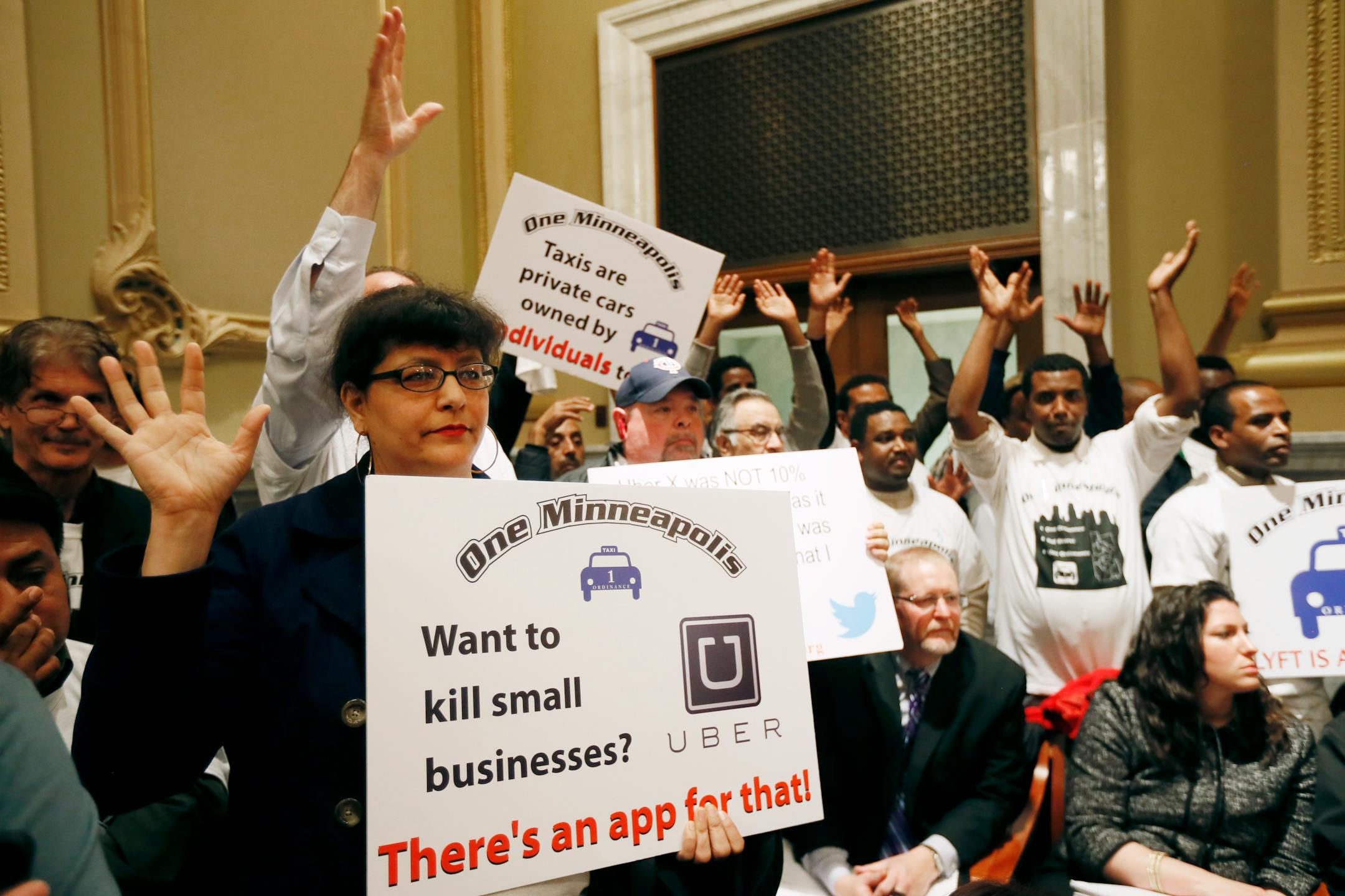 Bambi Barclay, a driver for Blue & White, and other drivers attend the Minneapolis City council meeting on Tuesday. Taxi drivers and supporters of app-based transportation companies testified on a bill that would legalize services like Lyft and Uber.