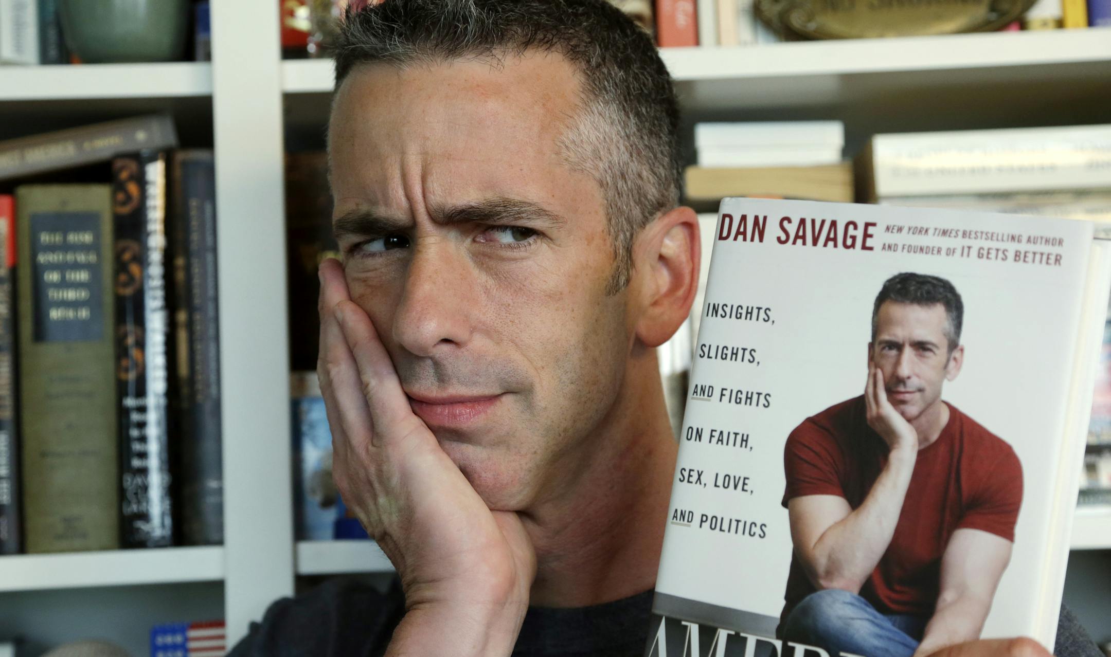 In this photo taken on May 22, 2013, author Dan Savage is in his home in Seattle. Savage's latest book, "American Savage," was released on Tuesday, May 28. (AP Photo/Elaine Thompson) ORG XMIT: MIN2013061914593510
