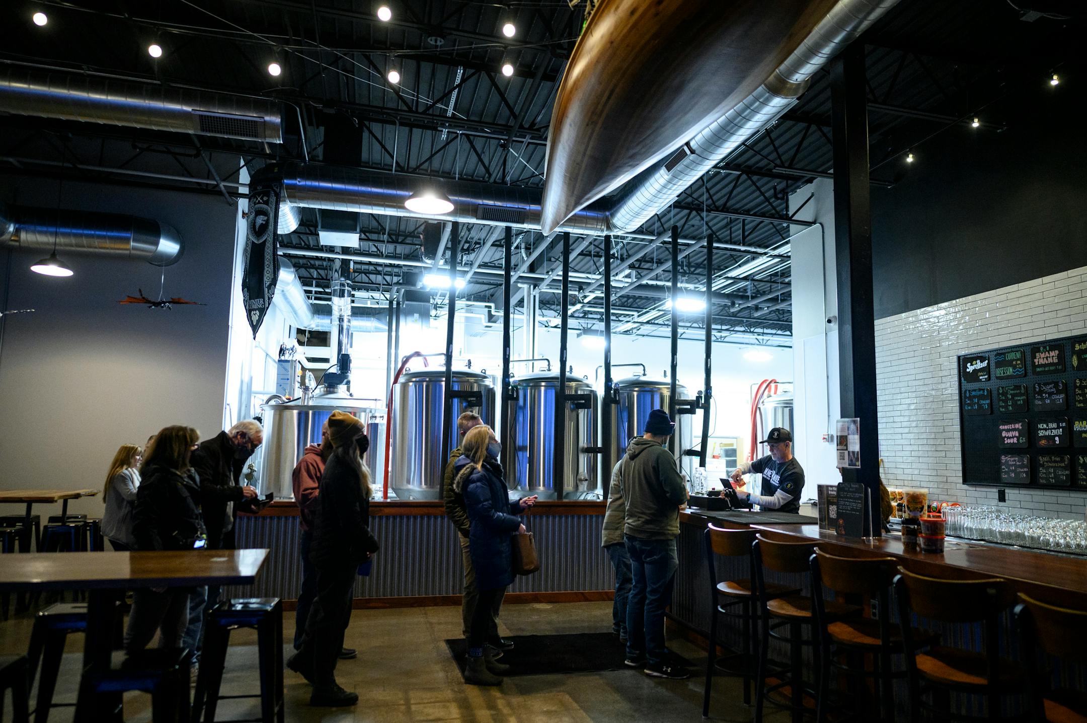 Patrons line up for beers during a soft opening for founders club members Wednesday, Feb. 9, 2022 at Nine Mile Brewing in Bloomington, Minn.
