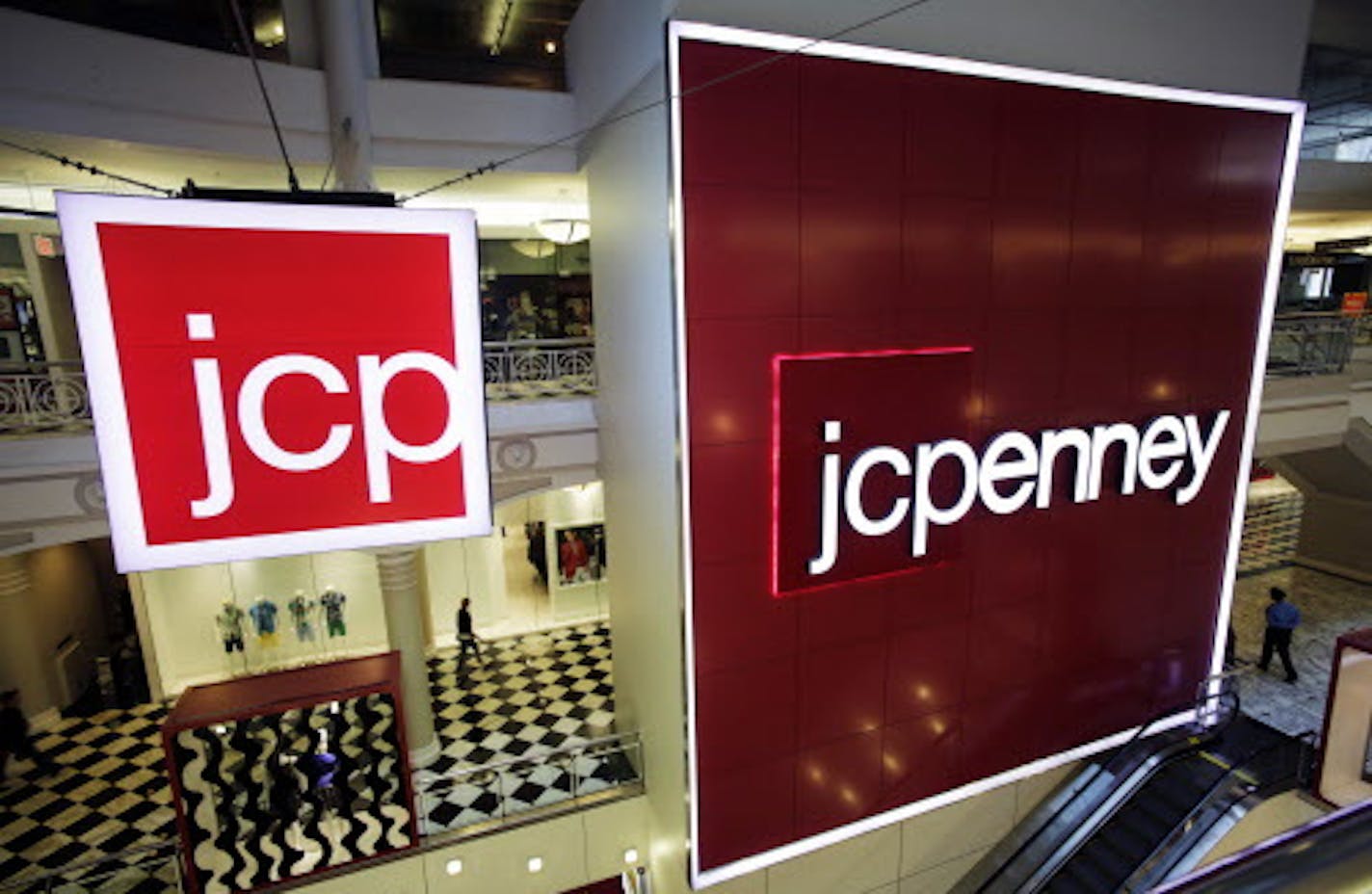 FILE - In this April 9, 2013, file photo, signage at a J.C. Penney store is displayed in New York. J.C. Penney is listing the 138 locations it will shutter in the coming months as the retailer seeks to cut costs and improve its profitability. J.C. Penney Co. is hurting as more people shop online instead of heading to the mall. The closures are part of the company's previously announced plans to focus on its best-performing stores. (AP Photo/Mark Lennihan, File)