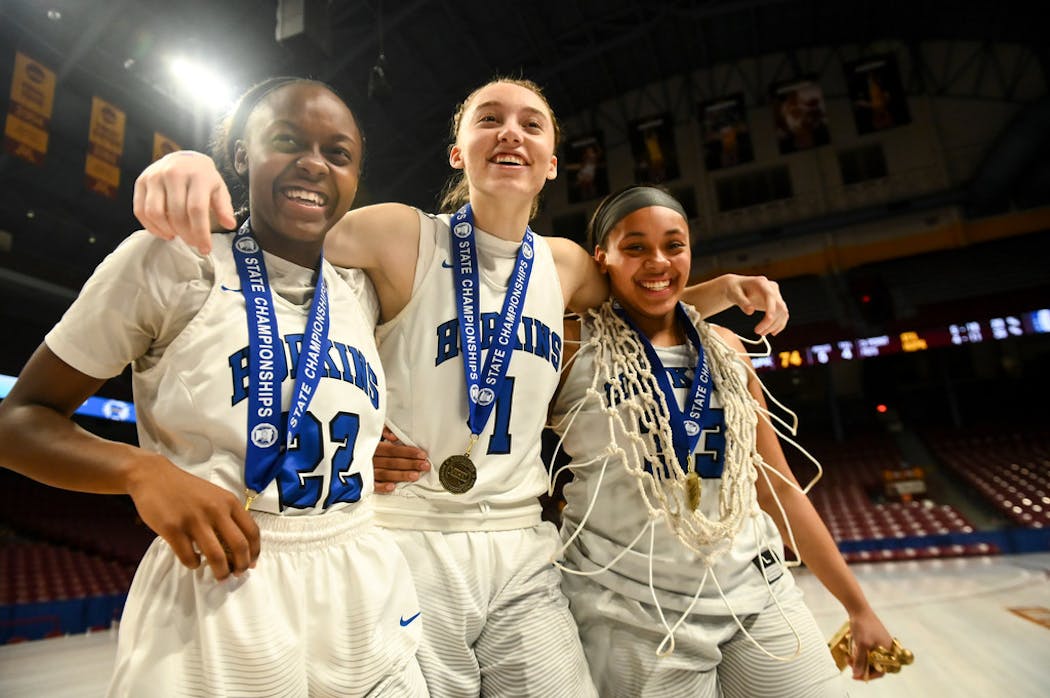 Bueckers (center) and her Hopkins teammates Kayla Adams (left) and Dlayla Chakolis (right) celebrate their state championship victory in March 2019.