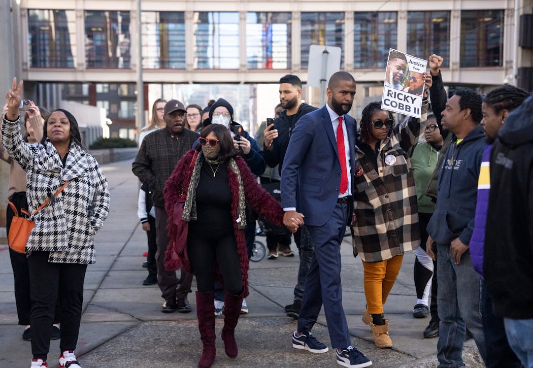 The family of Ricky Cobb II, mother Nyra Fields-Miller, in red coat, and their lawyer Bakari Sellers, red tie, watched as trooper Ryan Londregan and his supporters walked past after the first court appearance for Londregan to answer to murder and manslaughter charges in the killing Cobb during a traffic stop last summer.