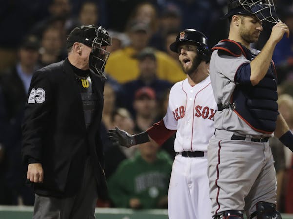 Boston Red Sox' Dustin Pedroia argues a strikeout call with home plate umpire Lance Barksdale, left, during the ninth inning of a baseball game at Fen