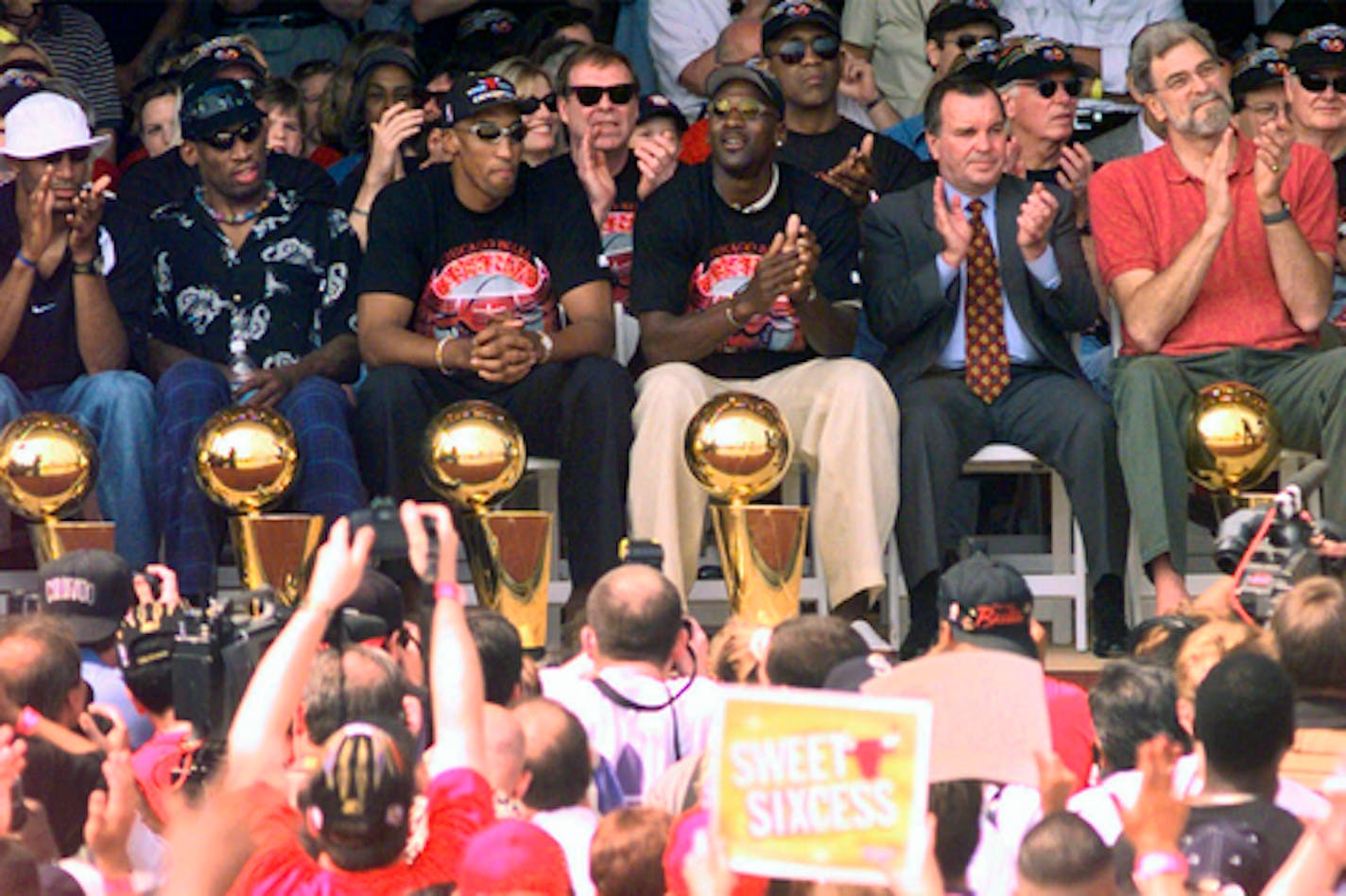 FILE - In this June 16, 1998, file photo, NBA Champions, from left: Ron Harper, Dennis Rodman, Scottie Pippen, Michael Jordan and coach Phil Jackson are joined on stage by Chicago Mayor Richard Daley, second from right, during a city-wide rally in Chicago to celebrate the Chicago Bulls 6th NBA championship. Jordan described his final NBA championship season with the Chicago Bulls as a "trying year." "We were all trying to enjoy that year knowing it was coming to an end," Jordan told Good Morning America on Thursday, April 16, 2020.  (AP Photo/Beth A. Keiser, File)