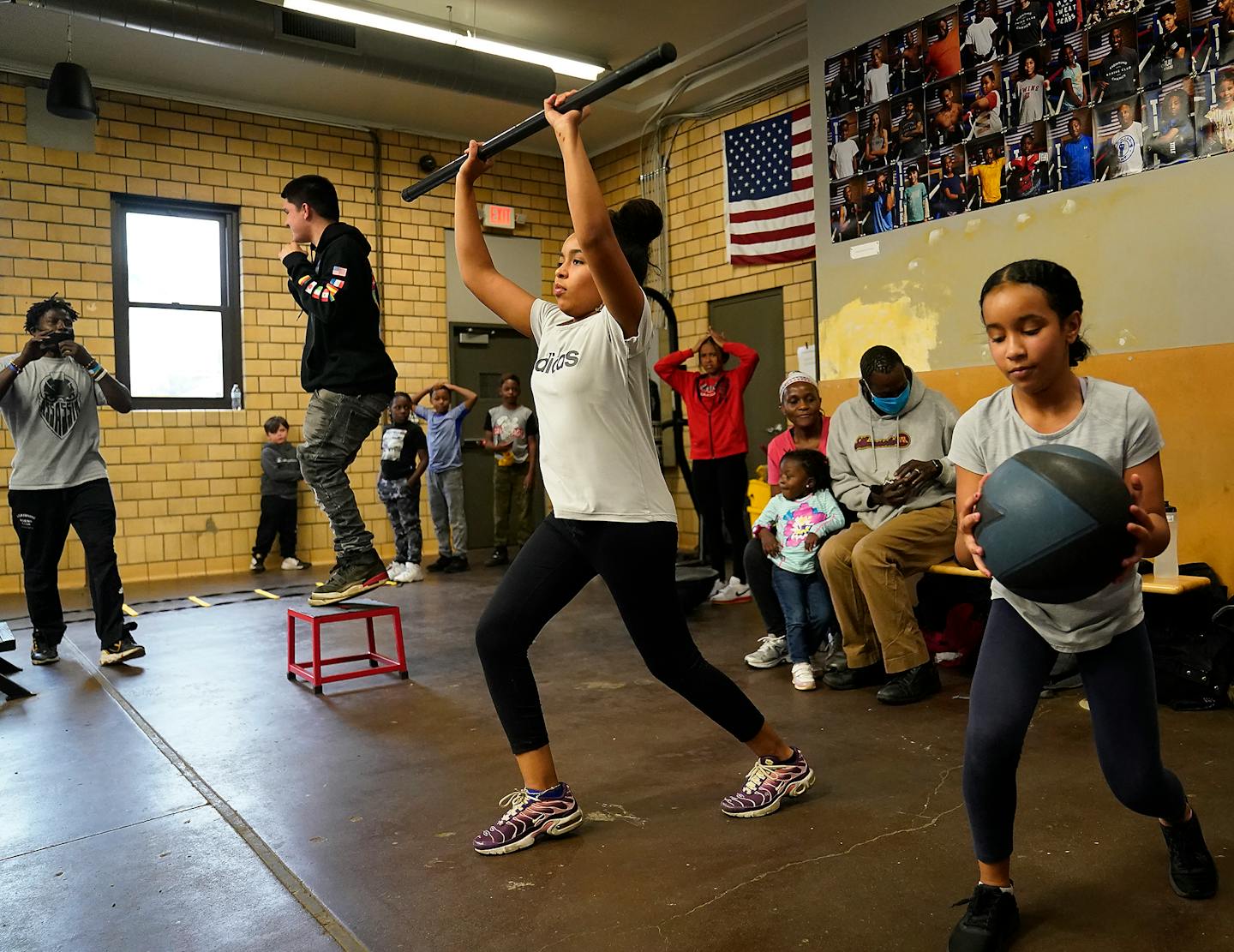 Northside Boxing Club coach Mohammed Kayongo, left, encouraged youth including sisters Aatiqah Haji, 10, right to left, and Fatima Haji, 13, during a class Monday in Minneapolis. ]