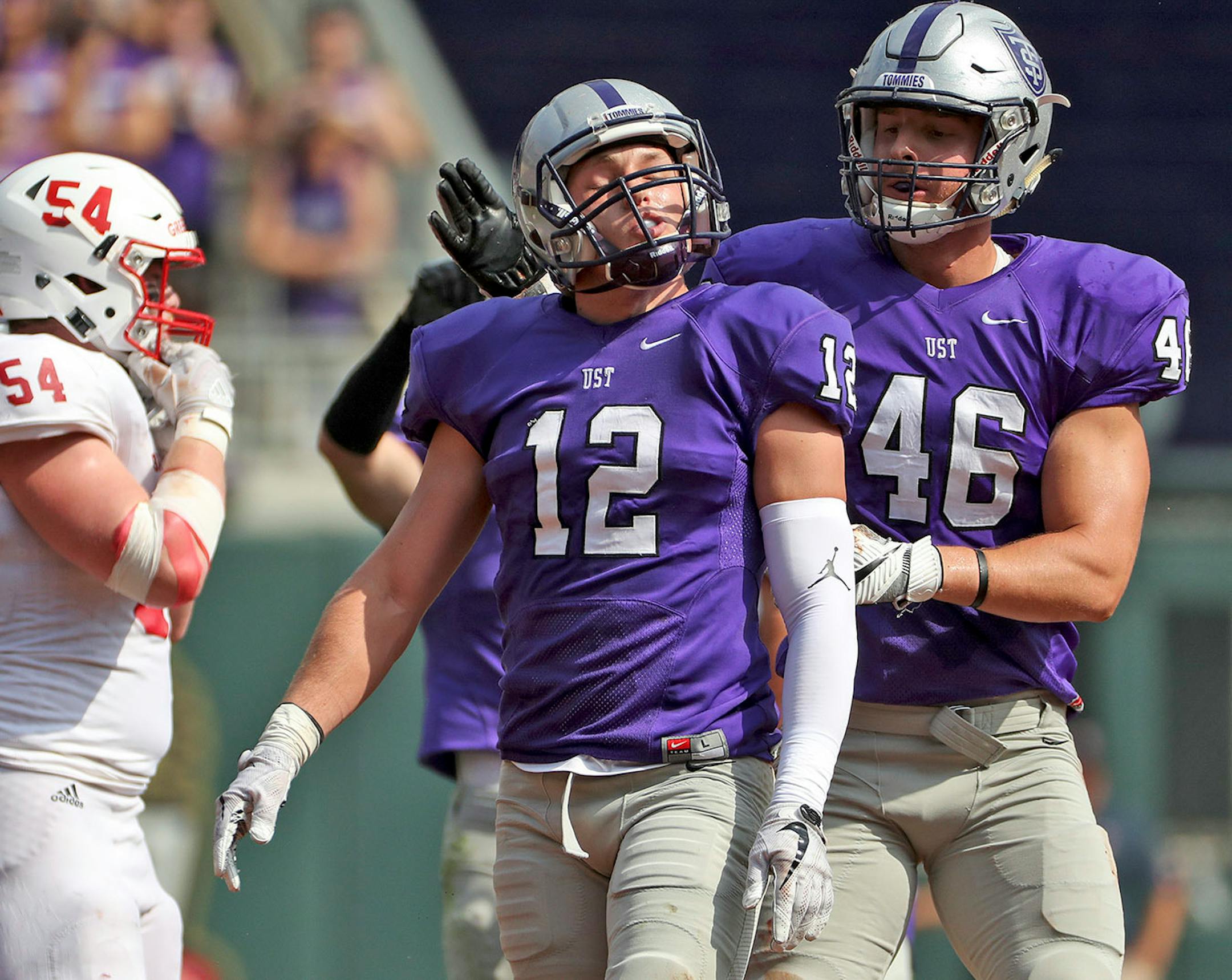 University of St. Thomas linebacker Dylan Andrew (12) was congratulated by University of St. Thomas defensive end Jake LeVahn (46) after making a quarterback sack in the first half.